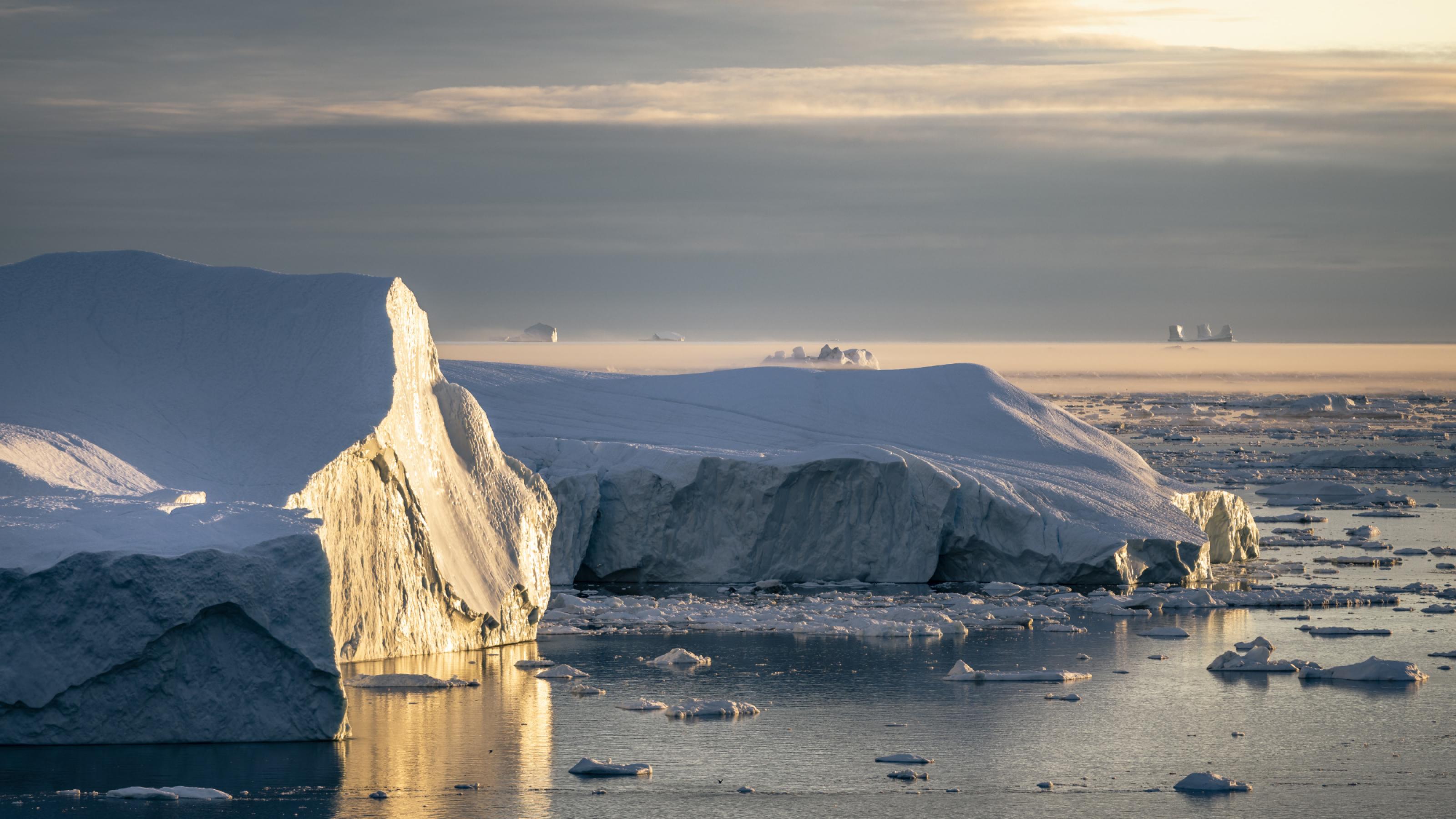 Auf dem Meer schwimmen Eisberge, die seitlich von der Sonne angeschienen werden. Rechte: Edward Felton, © 2021 Netflix, Inc.