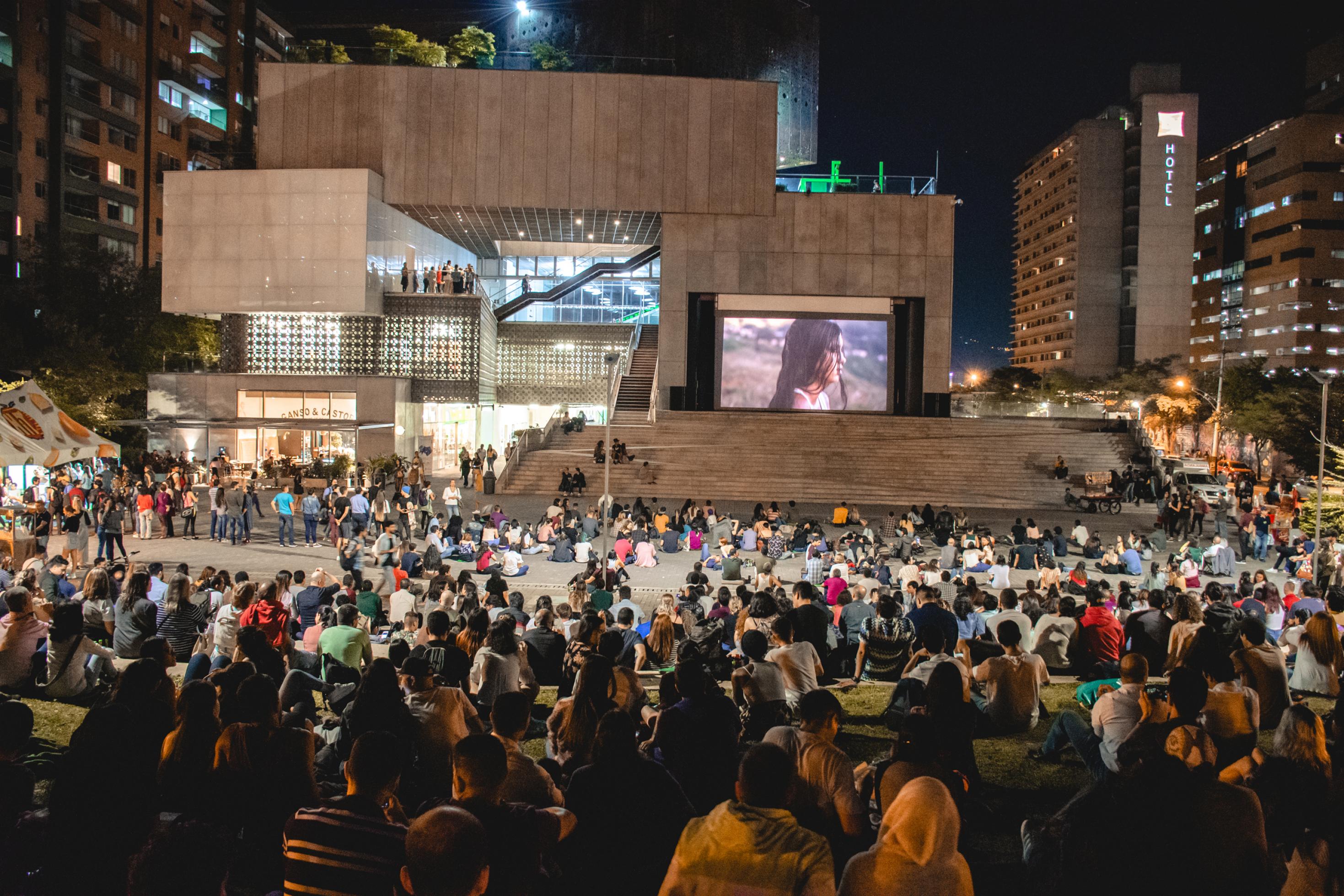 Eine Menschenmenge sitzt bei Nacht auf Stufen vor dem Museu de Arte in São Paulo.