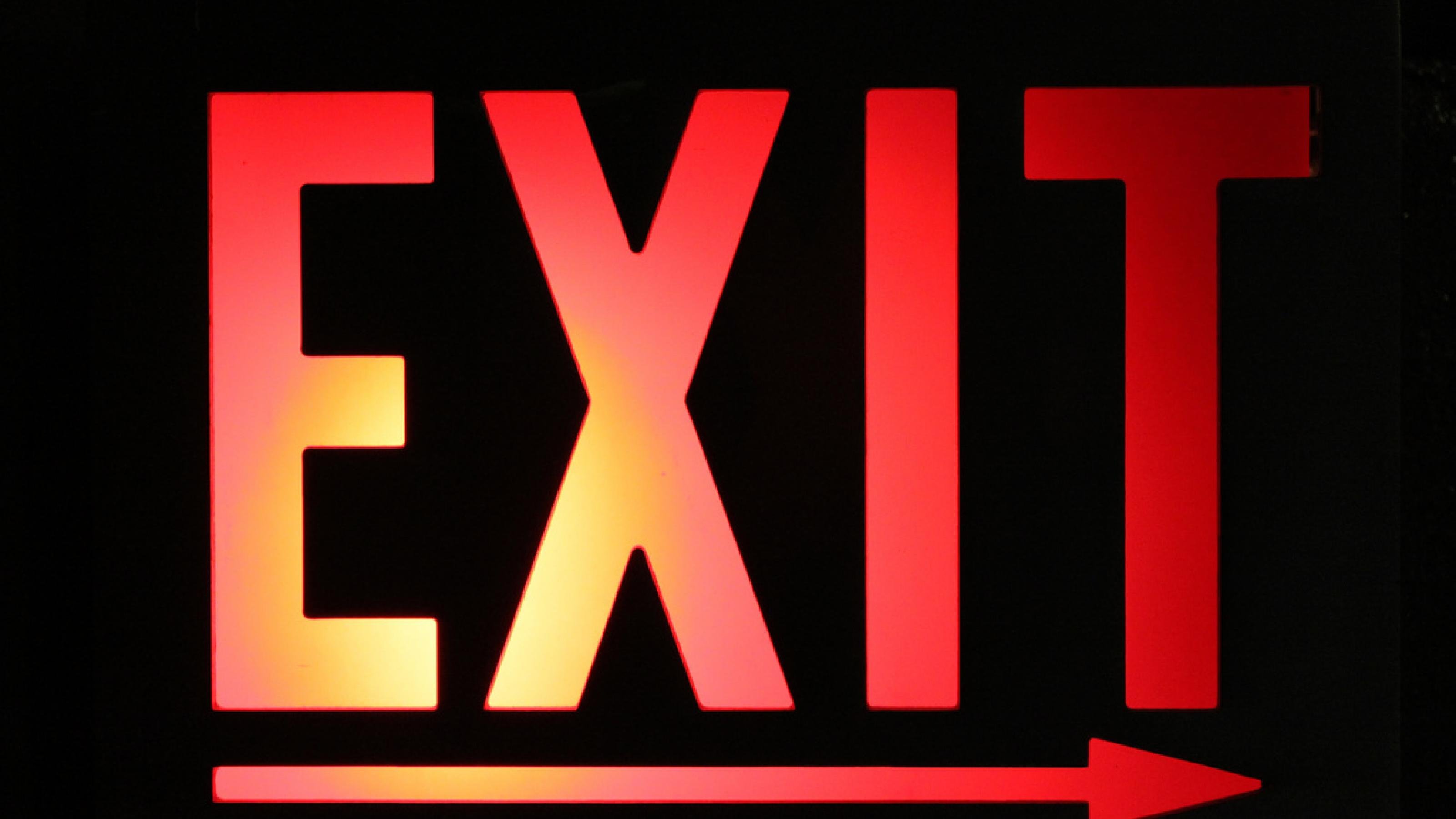 Beleuchtetes Exit-Schild auf schwarzem Hintergrund