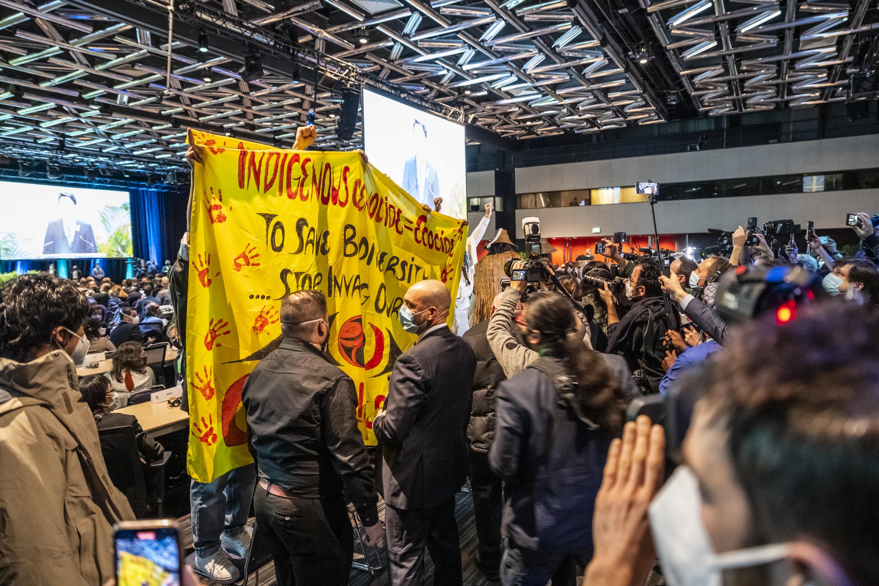 Indigene mit großem Plakat im Saal