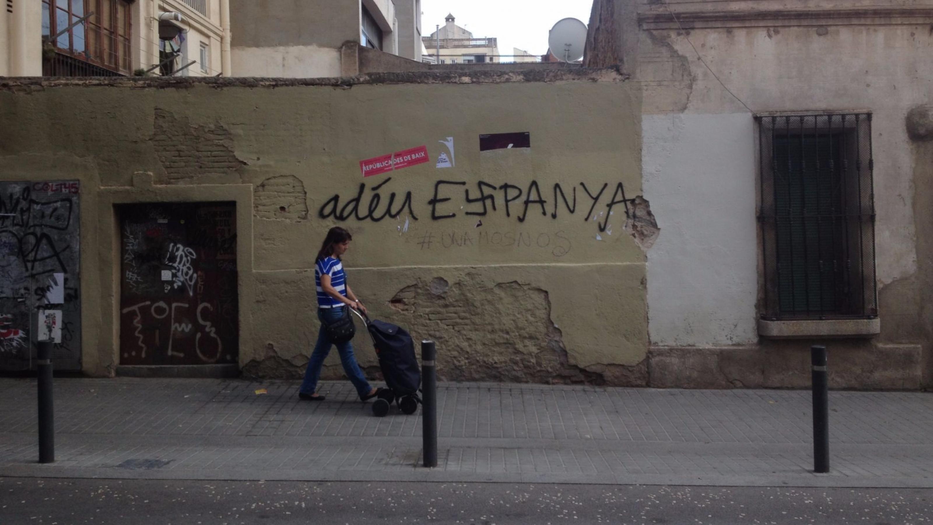 Eine Straße im Stadtviertel Grácia in Barcelona mit Graffiti „Adeu Espanya“, das s in Espanya als Hakenkreuz
