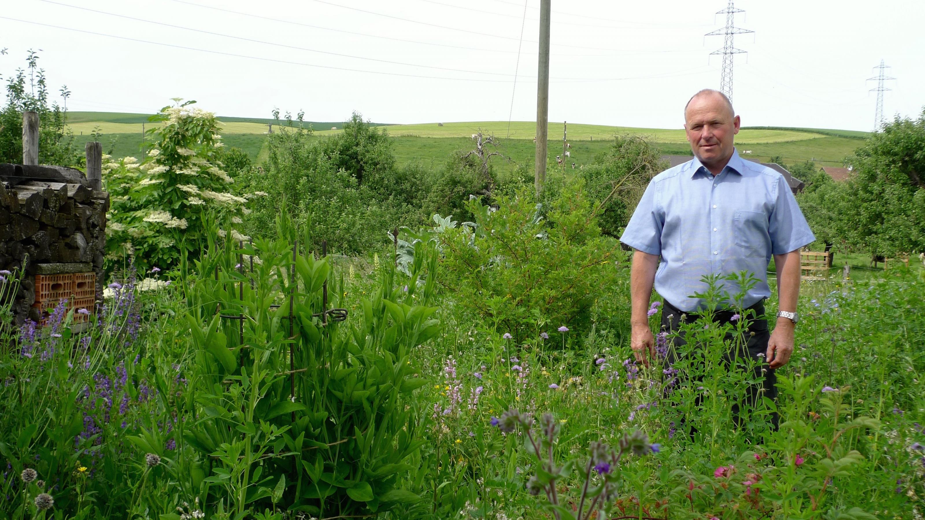 Andreas Aebi, Gründer des Vogeldorfes, steht in seinem Naturgarten in Alchenstorf, im Schweizer Emmental.