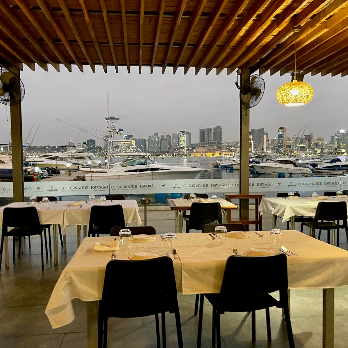 Esplanada do O Convés com vista para a marina e skyline de Luanda