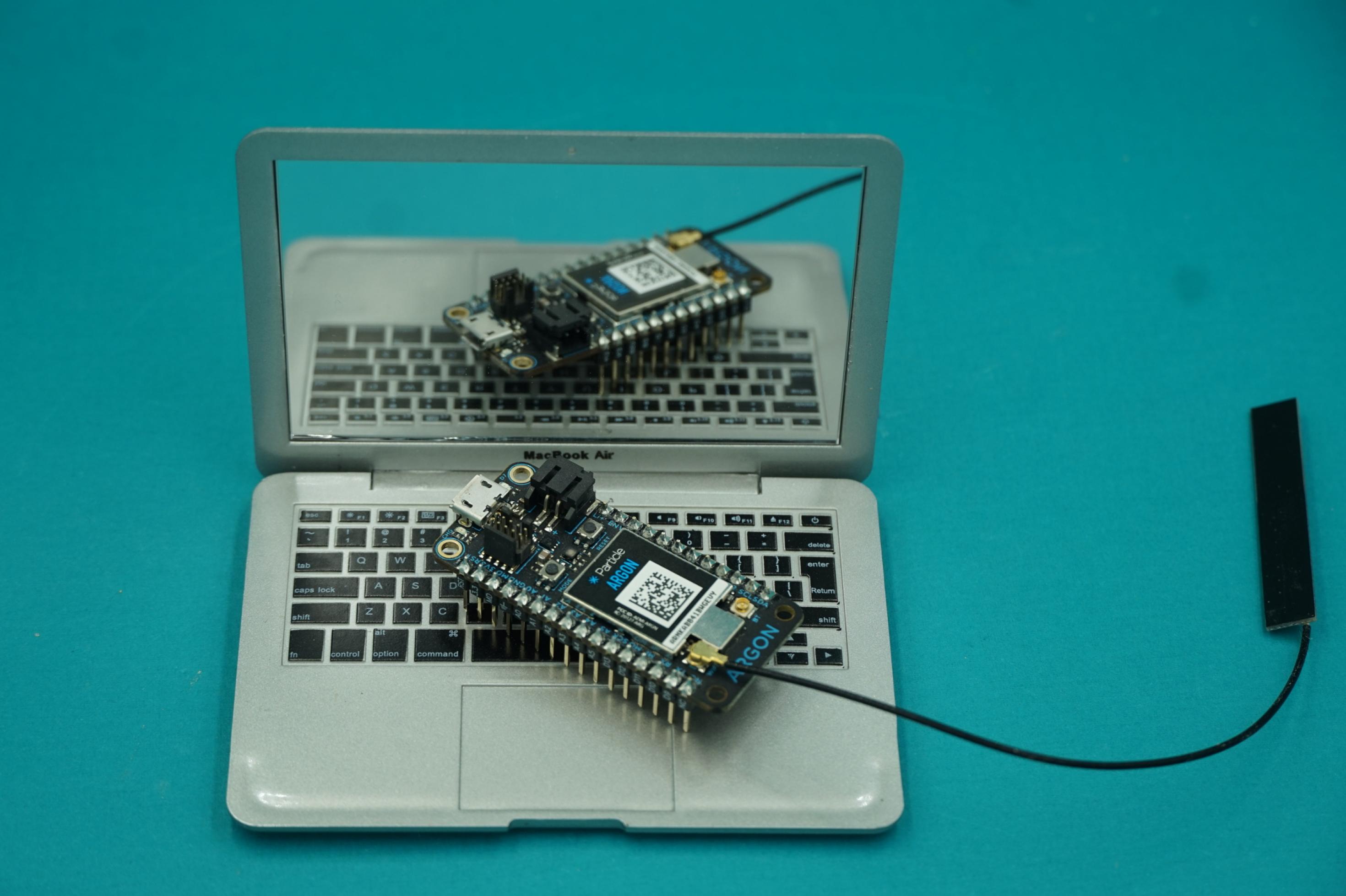 Der Particle Argon Mikrocontroller auf einem Puppen-Laptop