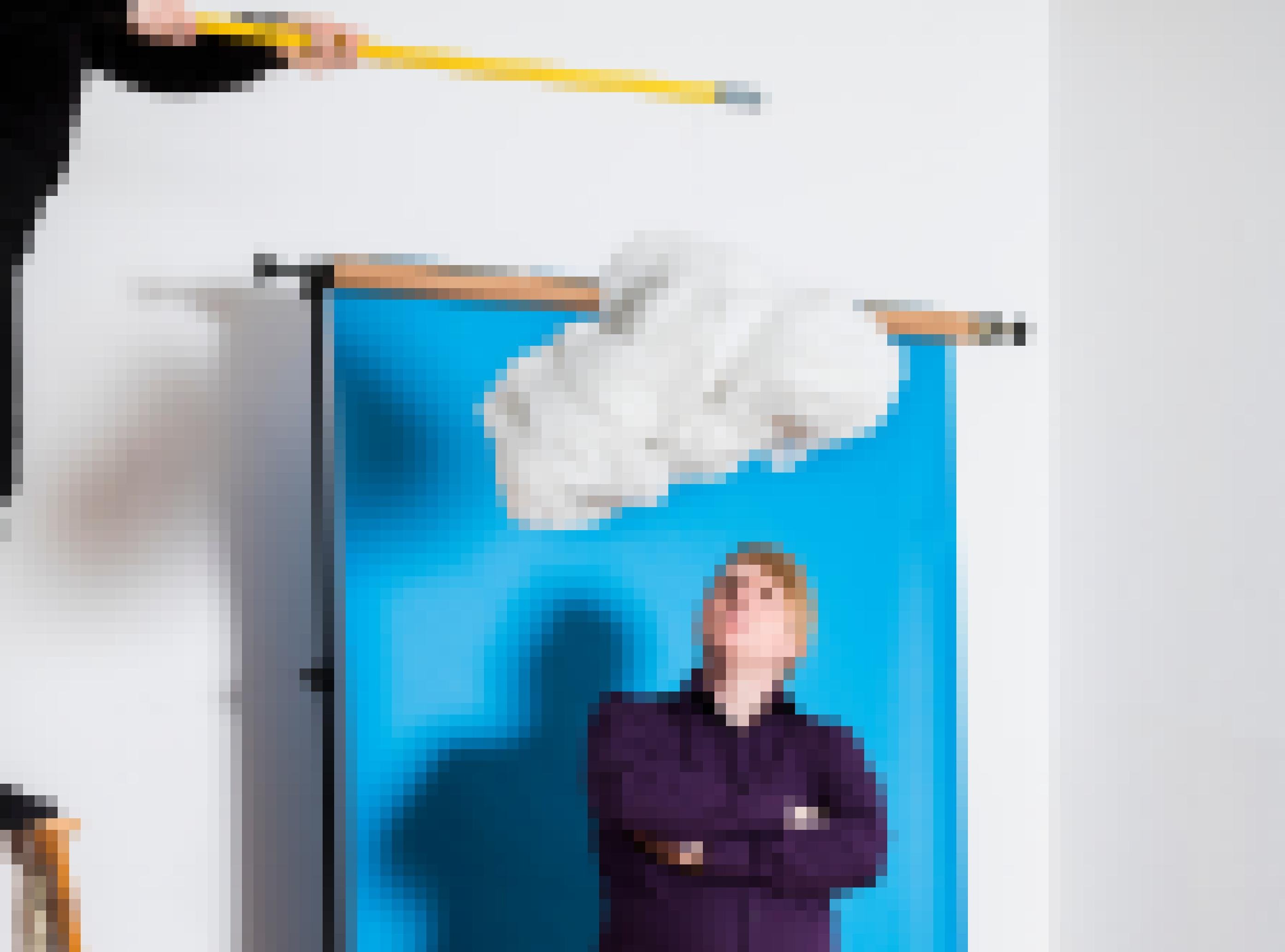 Moderator Vicari steht vor einem blauen Hintergrund. Über ihm ist eine Wolke abgebildet.