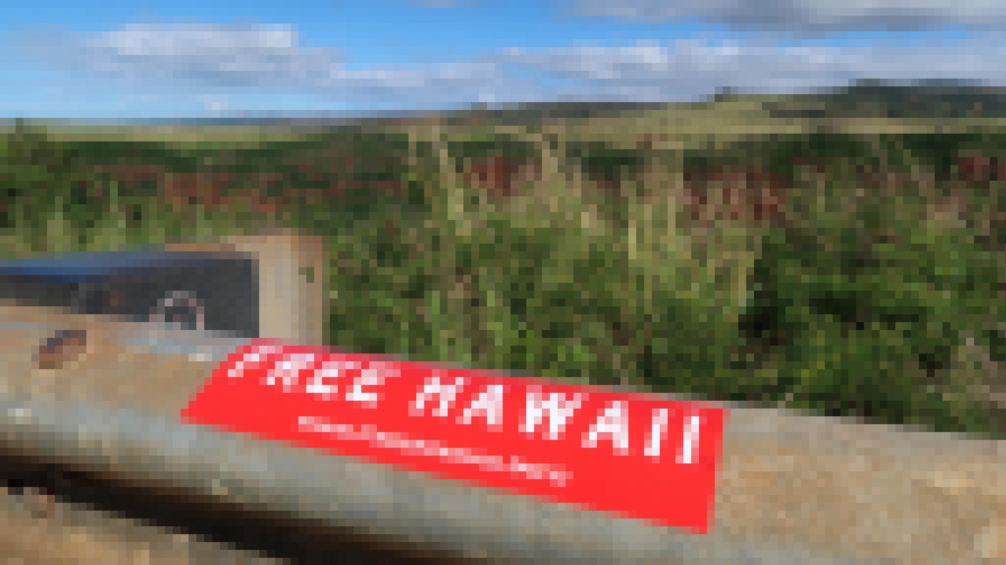 Ein roter Aufkleber klebt auf einem Geländer mit der Aufschrift: „Free Hawaii“