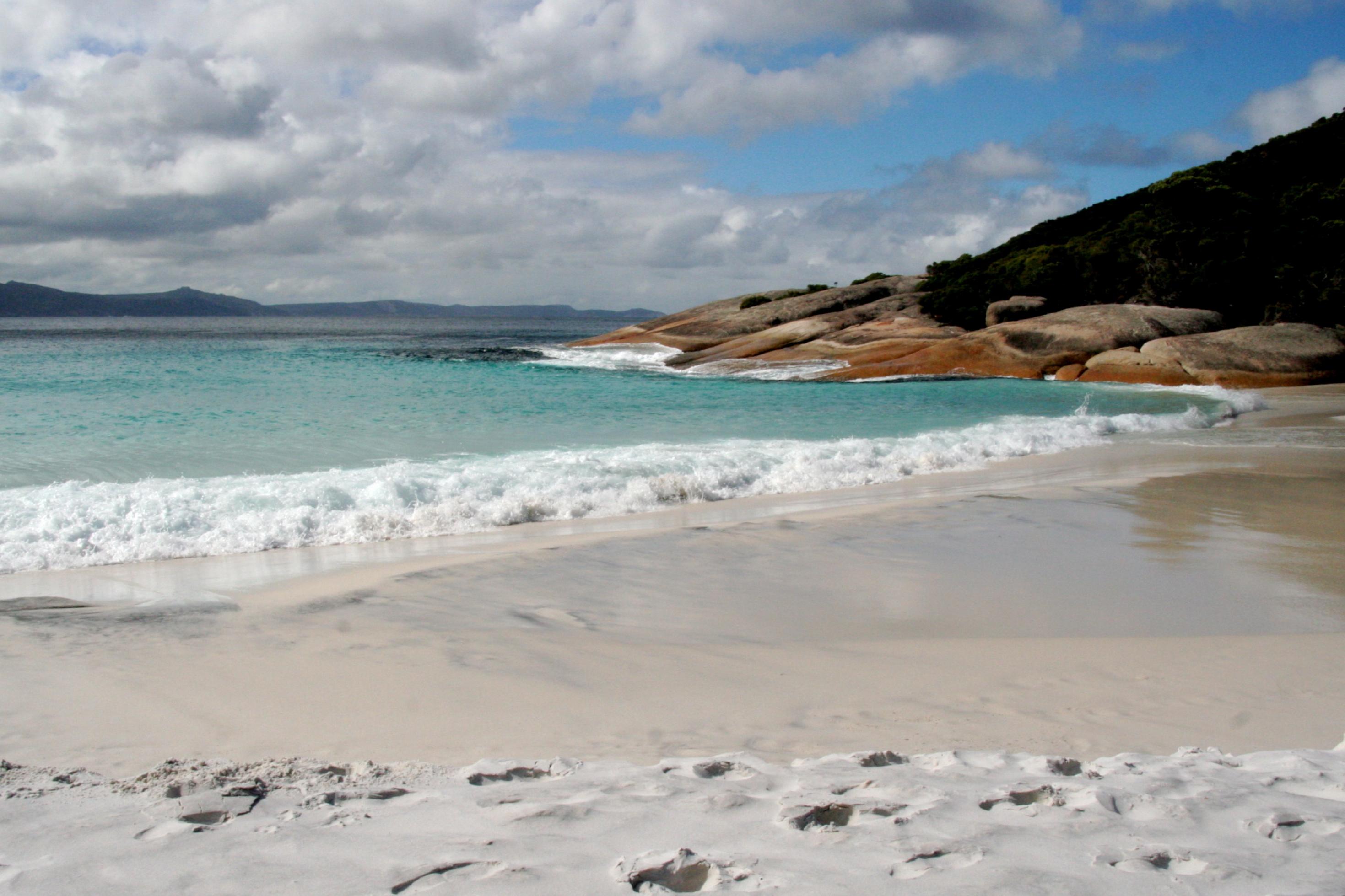 Wolken, Felsen, weißer Sand und Meer – Der Strand an der Südküste von Westaustralien liegt gleich um die Ecke von Misery Beach, der zum neuen besten Strand von Auutralien erwählt wurde.