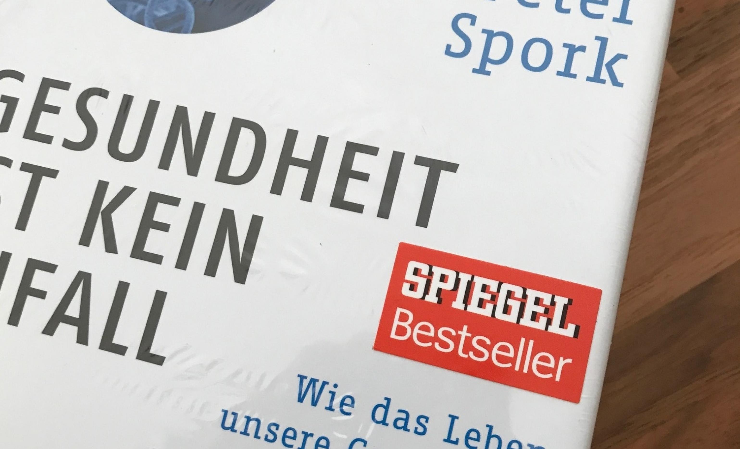 Auf dem Cover des Buchs „Gesundheit ist kein Zufall“ von Peter Spork klebt der Aufkleber „Spiegel Bestseller“.