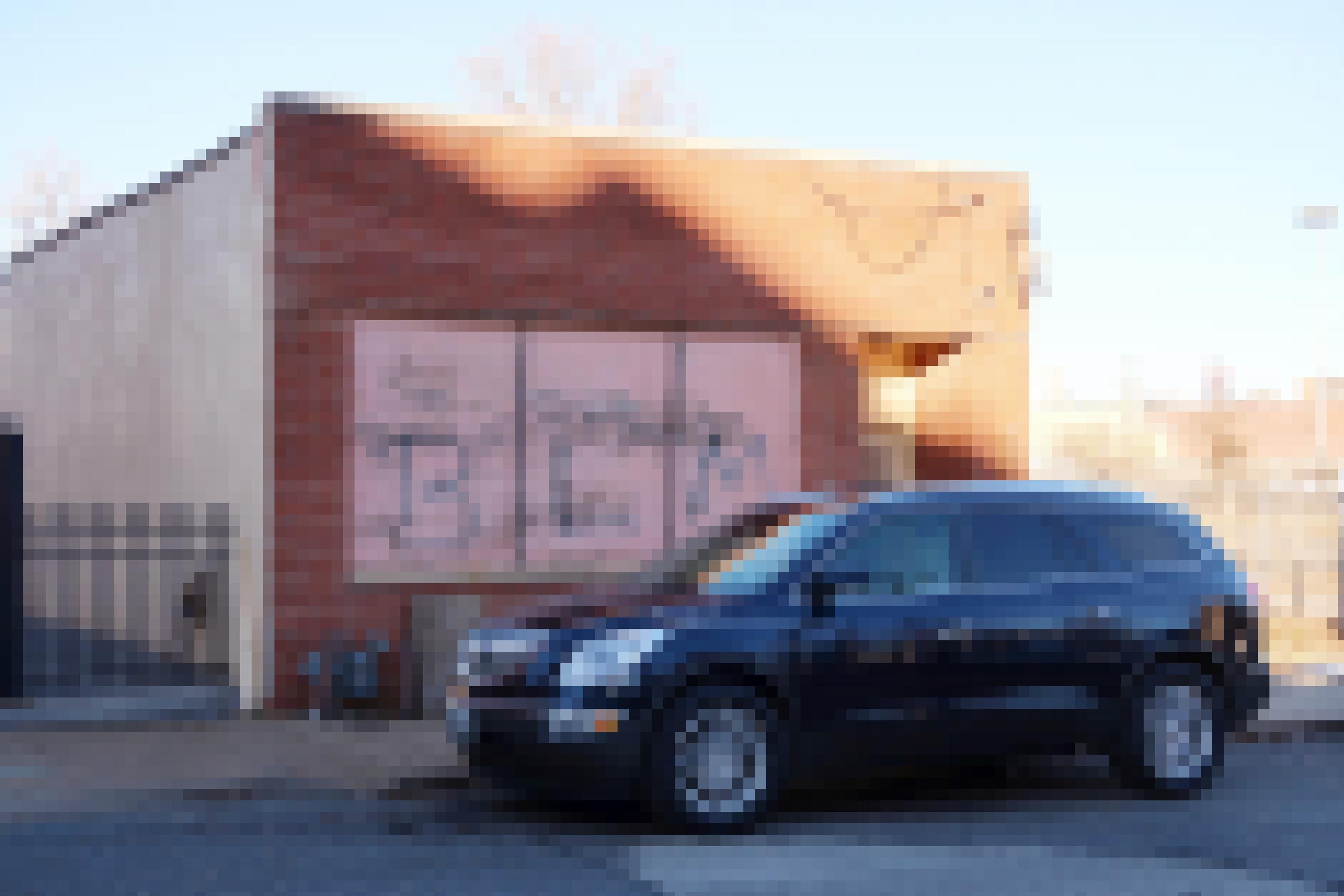 Ein Auto vor einer Wand mit der Aufschrift „BLM“.