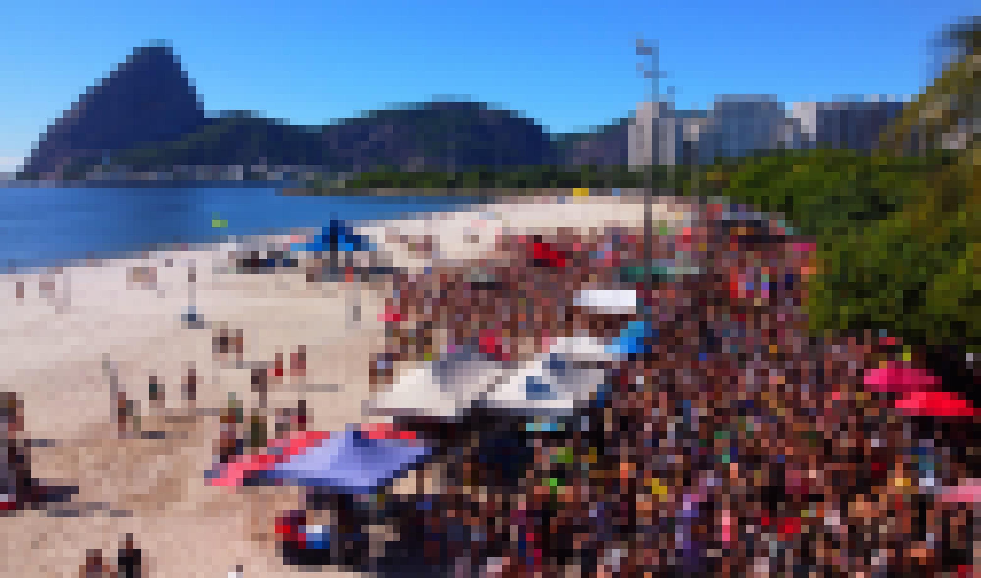 Eine Menschenmenge in Bikinis und Sommerkleidung am Strand versammelt.