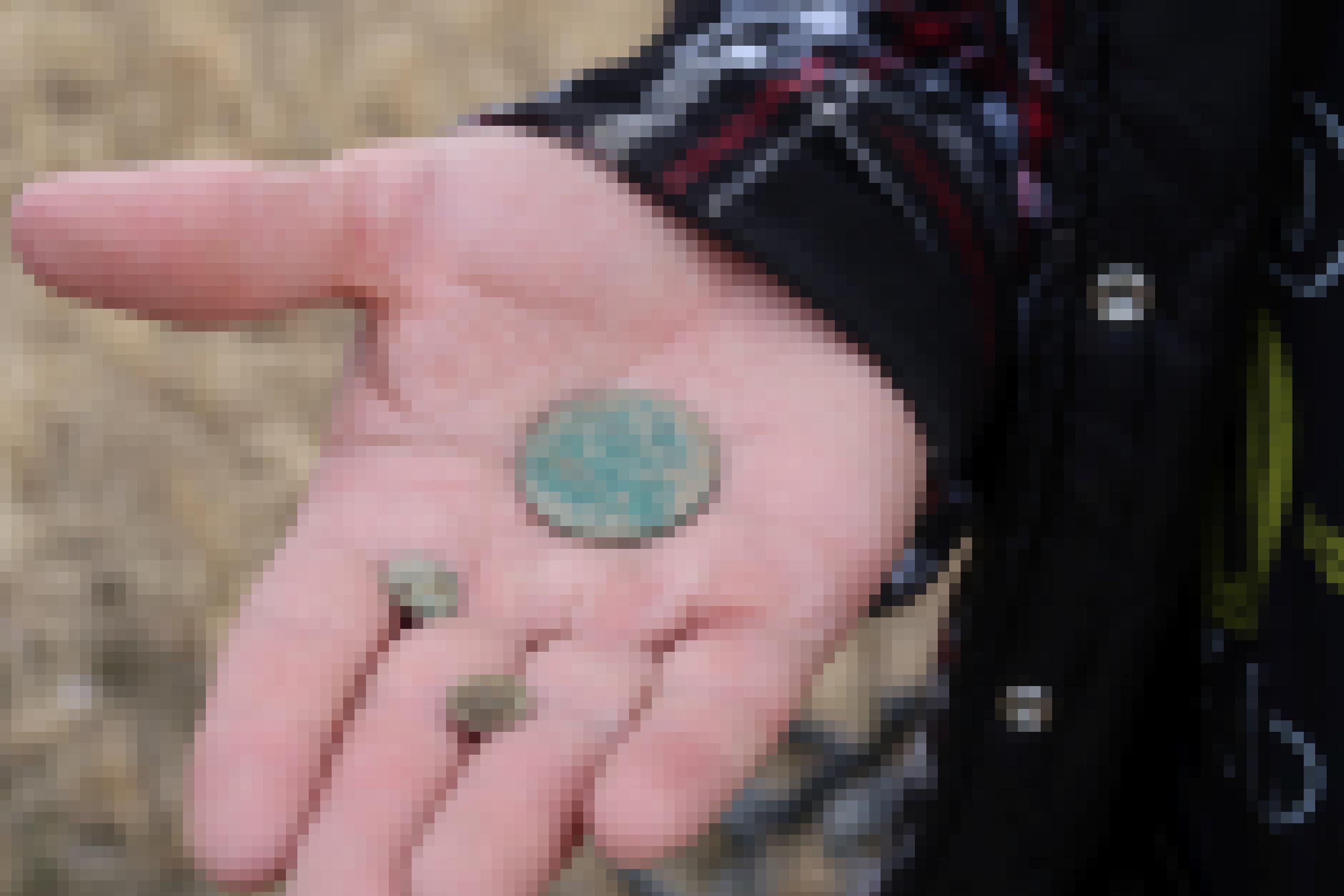 Nahaufnahme einer Handfläche, in der eine Münze liegt.