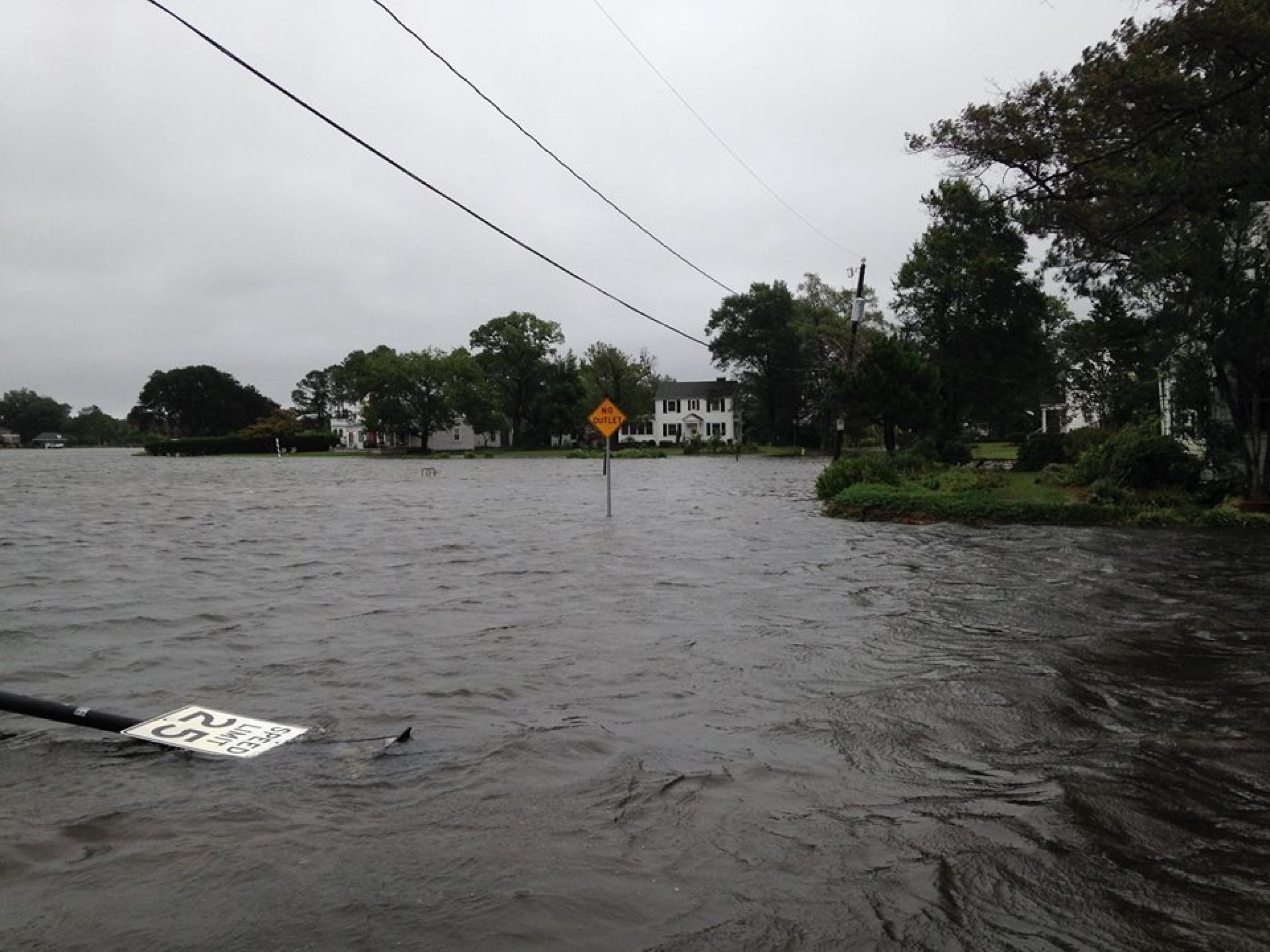 Eine überflutete Straße, im Wasser liegt ein umworbenes Verkehrsschild. Im Stadtteil Colonial Place von Norfolk/Virginia haben die Hausbesitzer nasse Füße statt Wasserblick.
