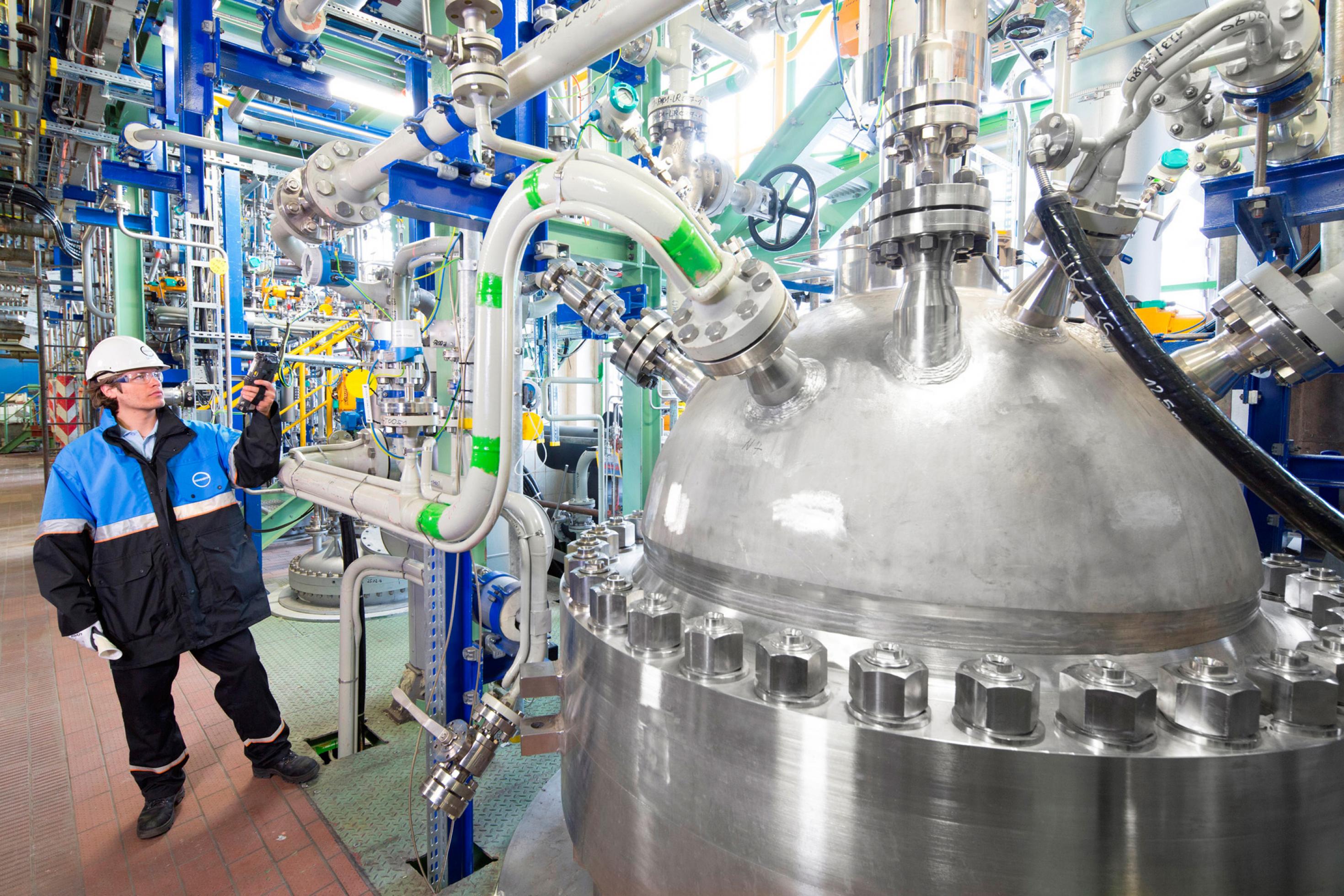 Ein Arbeiter steht an einer Produktionsanlage für CO2-Schaumstoff in einer großen Halle.