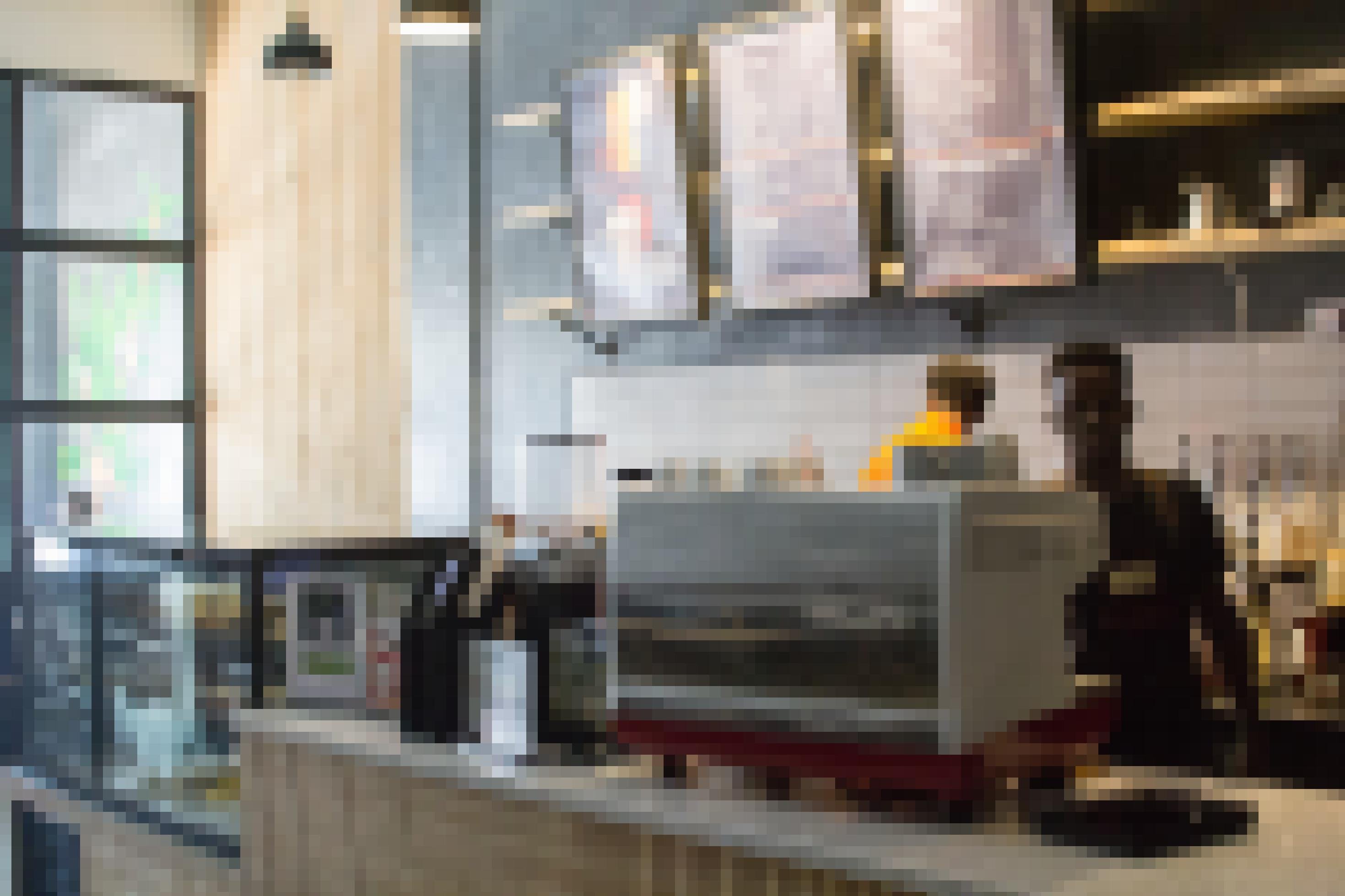 Die Angestellten im Café Beyden stehen hinter  dem Verkaufsthresen, bereiten Getränke an einer Espressomaschine zu. Ein modernes Ambiente.