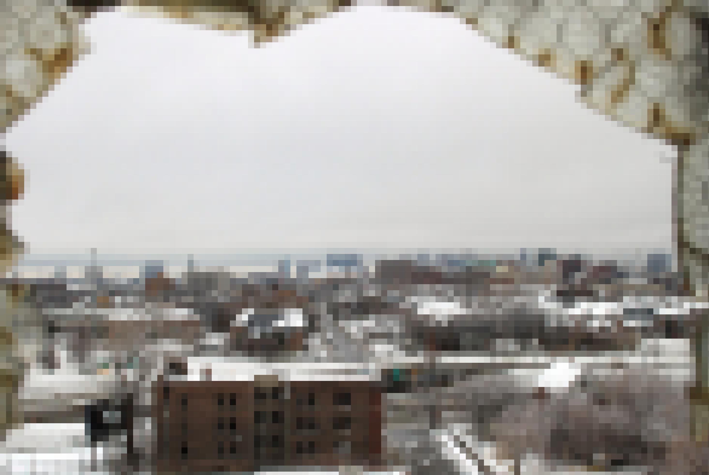Blick durch eine zerbrochene Fensterscheibe auf verlassene Fabrikhäuser.