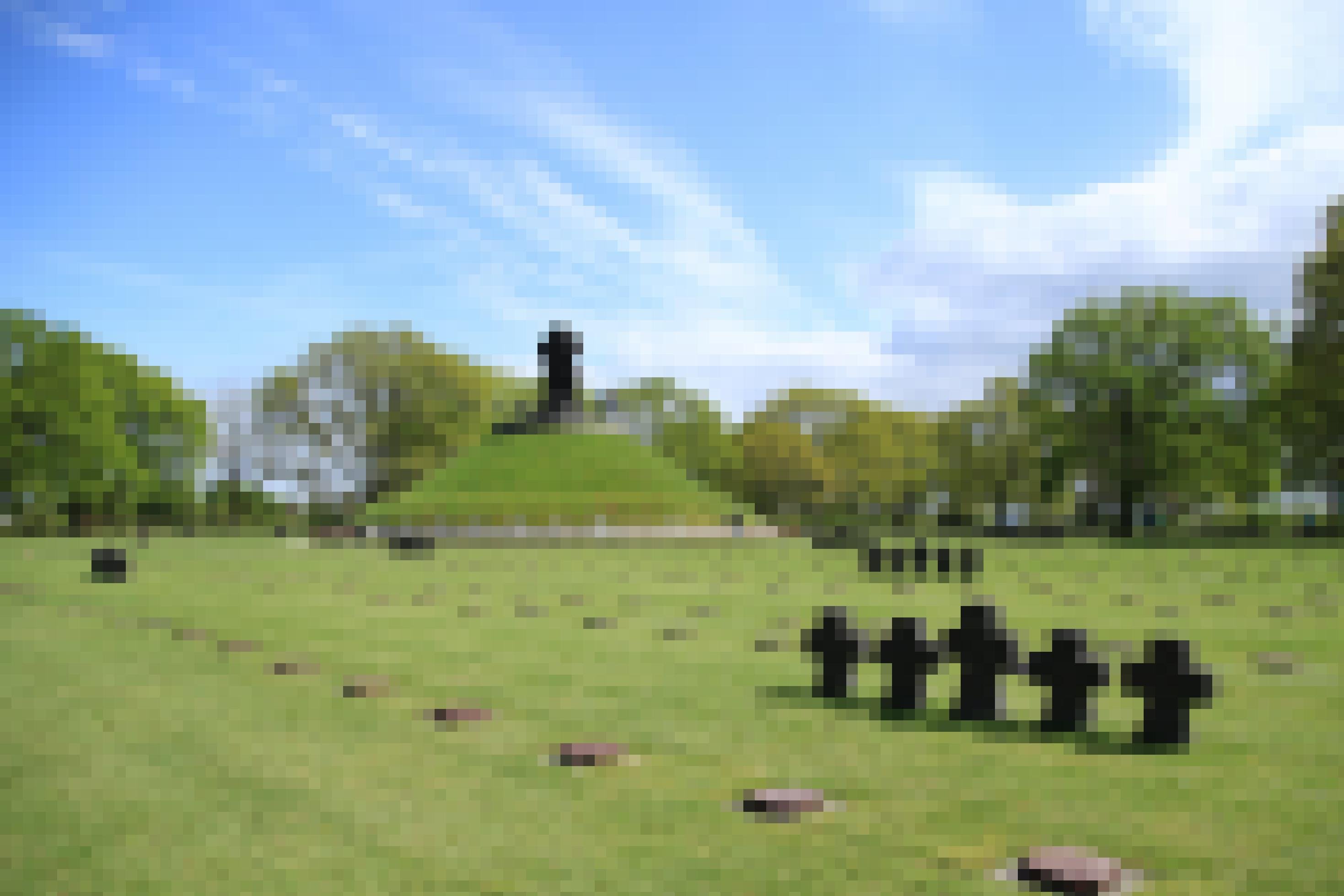 Ein Friedhof mit einigen steinernen Kreuzen und einer Erhöhung samt Kreuz-Denkmal.