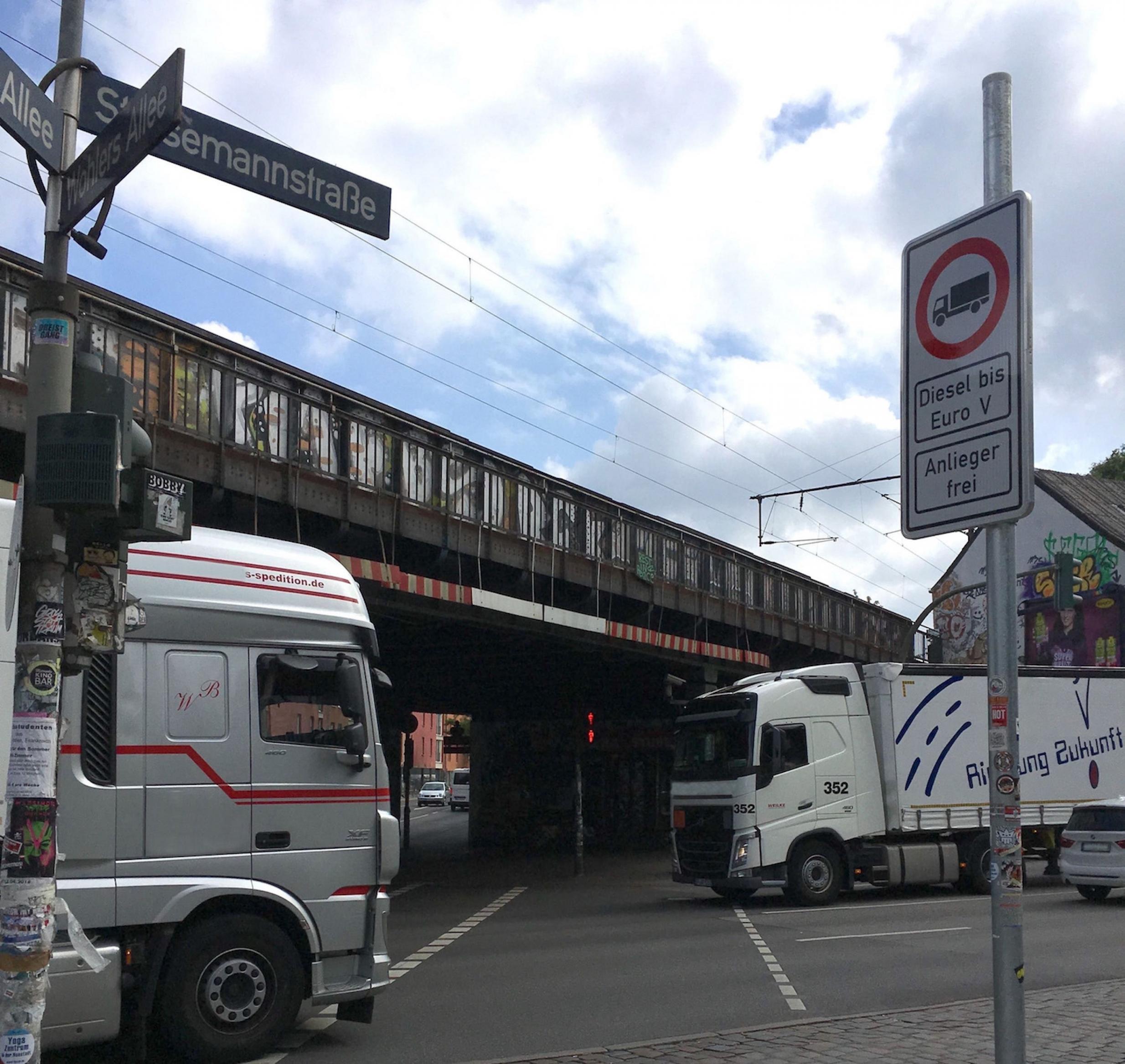 Zwei große Lastwagen begegnen sich an der Kreuzung Stresemannstraße und Max-Brauer-Allee in Hamburg. Man sieht rechts das Schild des Dieselfahrverbots.