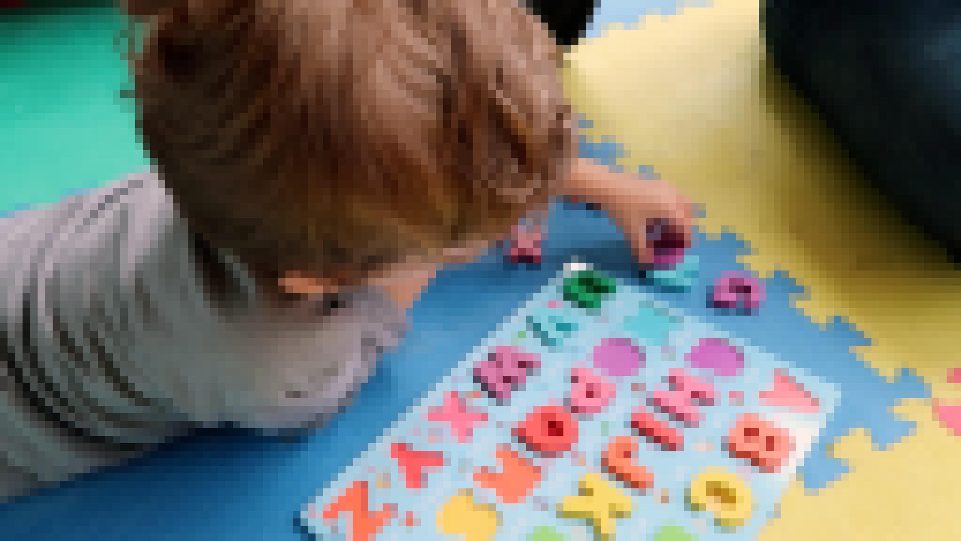 Ein Dreijähriger spielt mit bunten Holzbuchstaben.