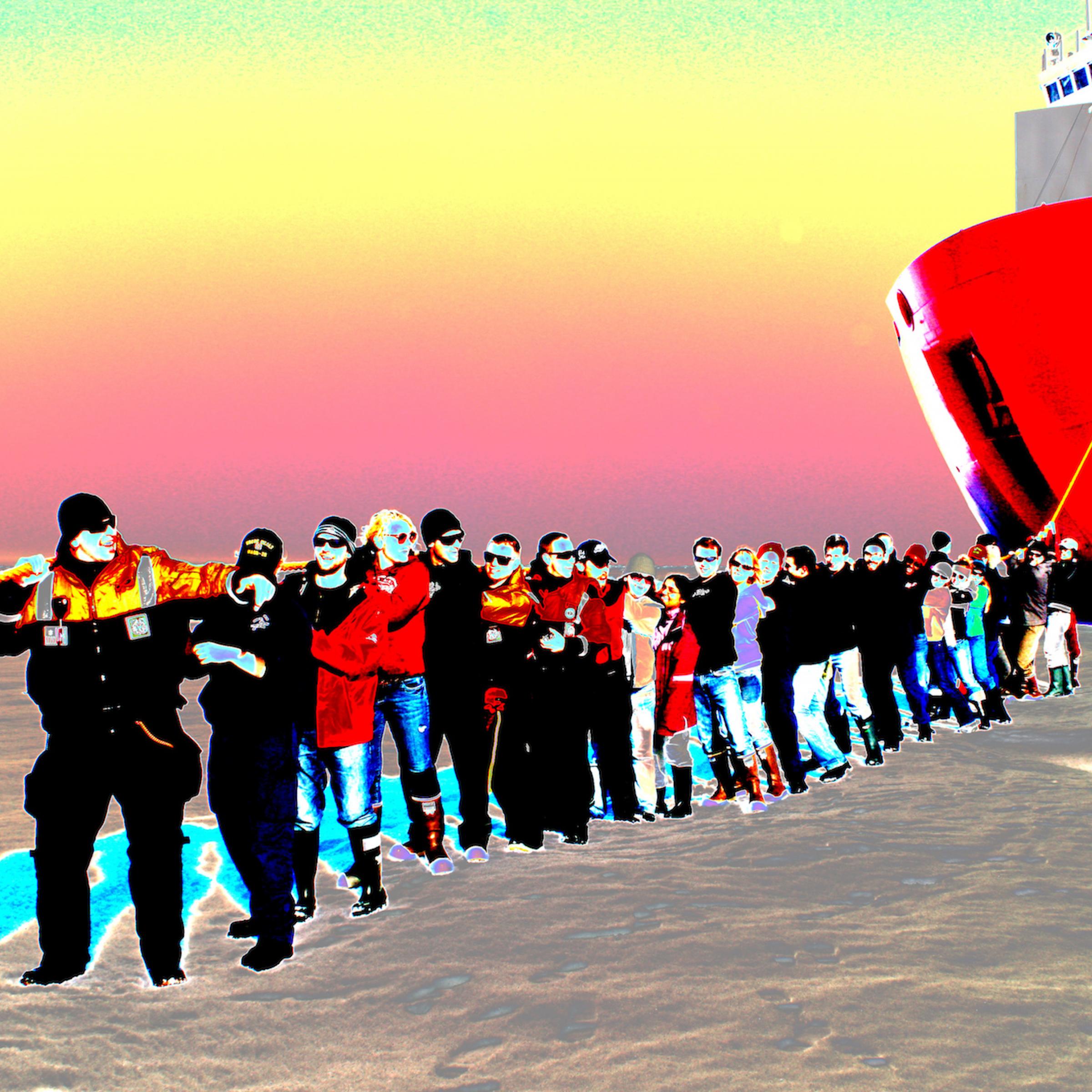 Eine Reihe von Menschen, angeführt von der Kapitänin, steht auf dem Eis und zieht an einer Trosse, die zum Bug eines Eisbrechers mit rotem Rumpf führt. Bei der Icescape-Mission der Nasa posiert die Besatzung des US-Coast-Guard-Schiffs „Healy“ 2011.