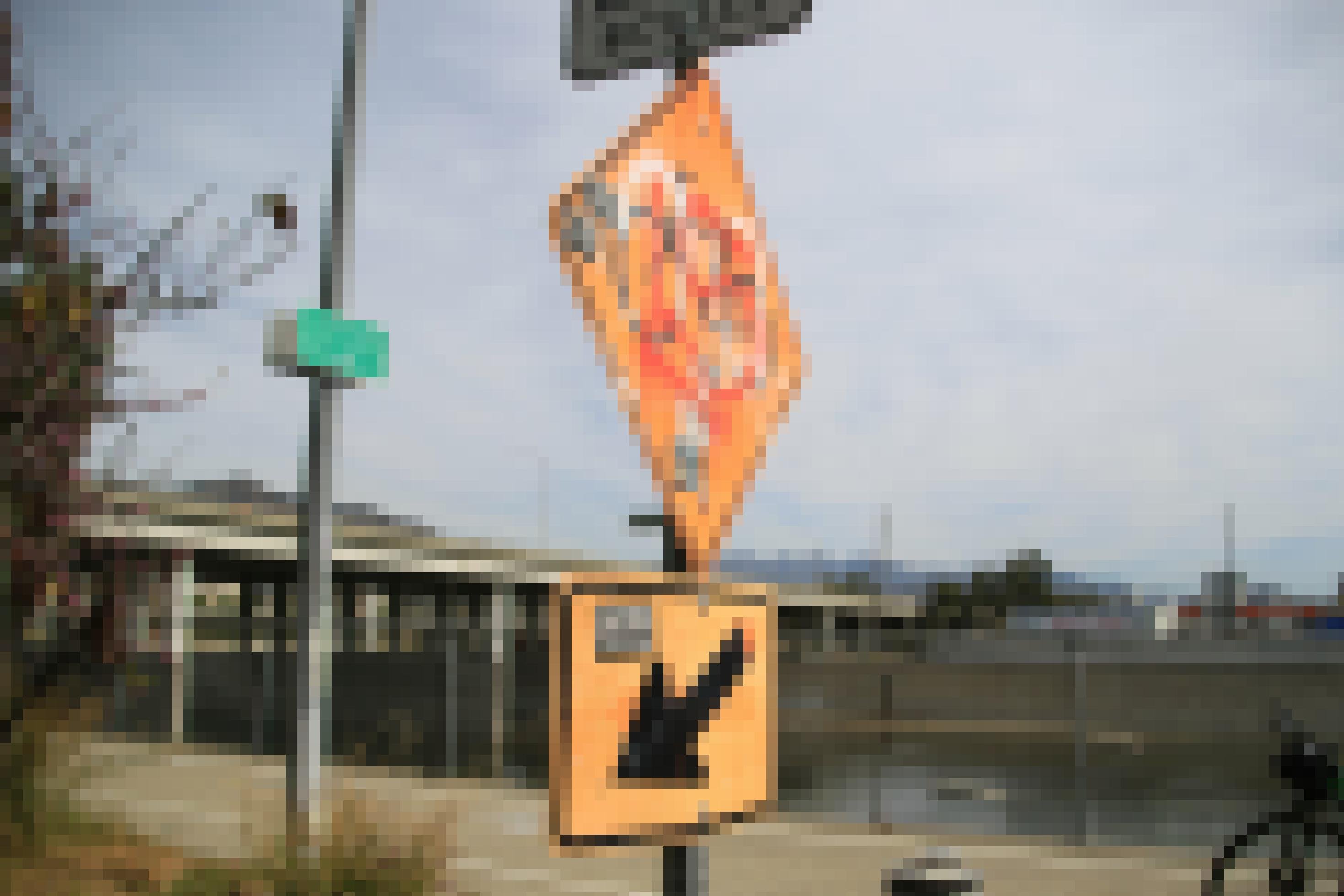 Ein Schild weist auf einen Radweg hin. Es ist mit Graffiti besprüht.