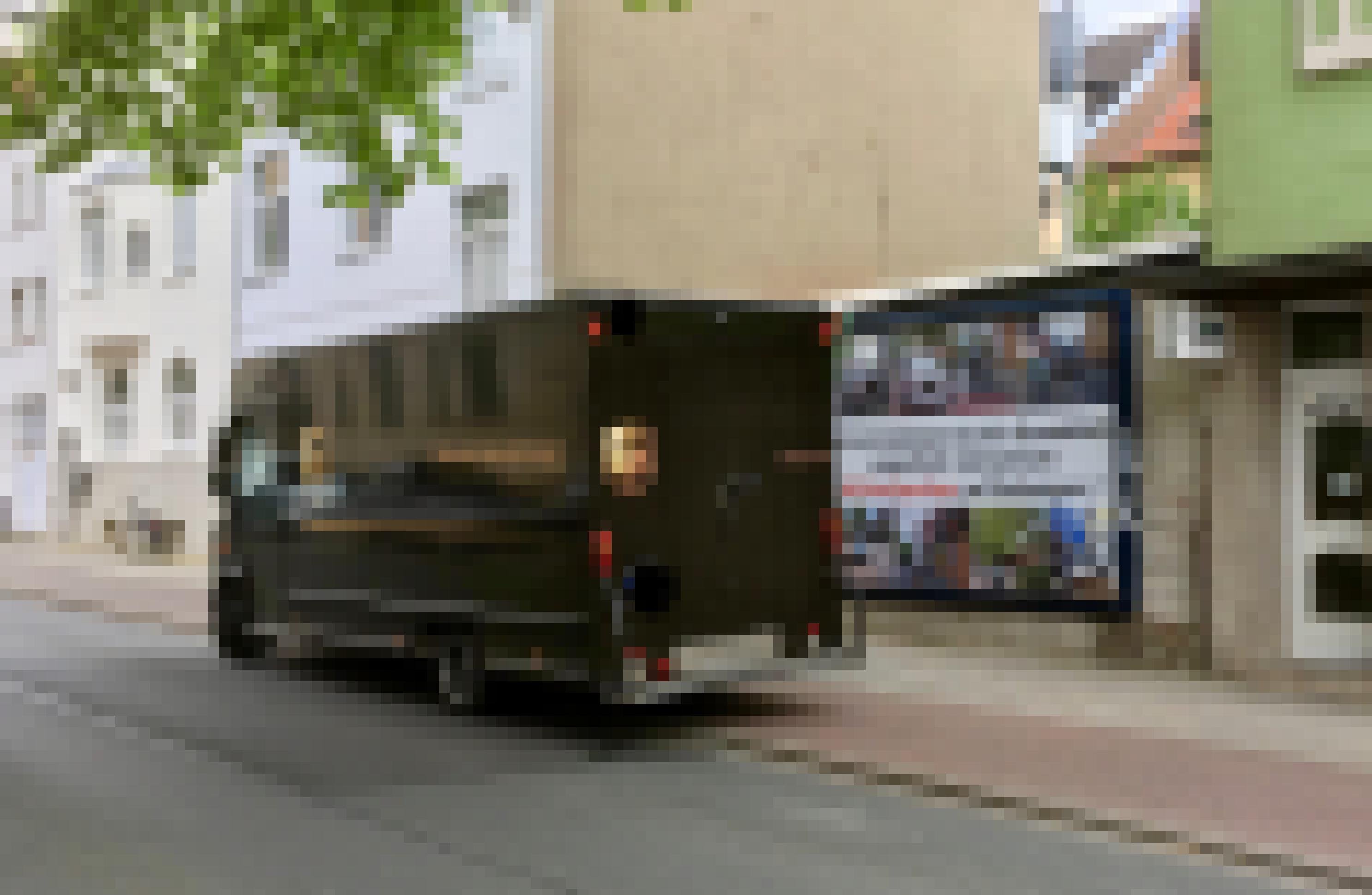 Ein großer Transporter steht mitten auf dem Rad- und Fußweg vor dem Plakat.