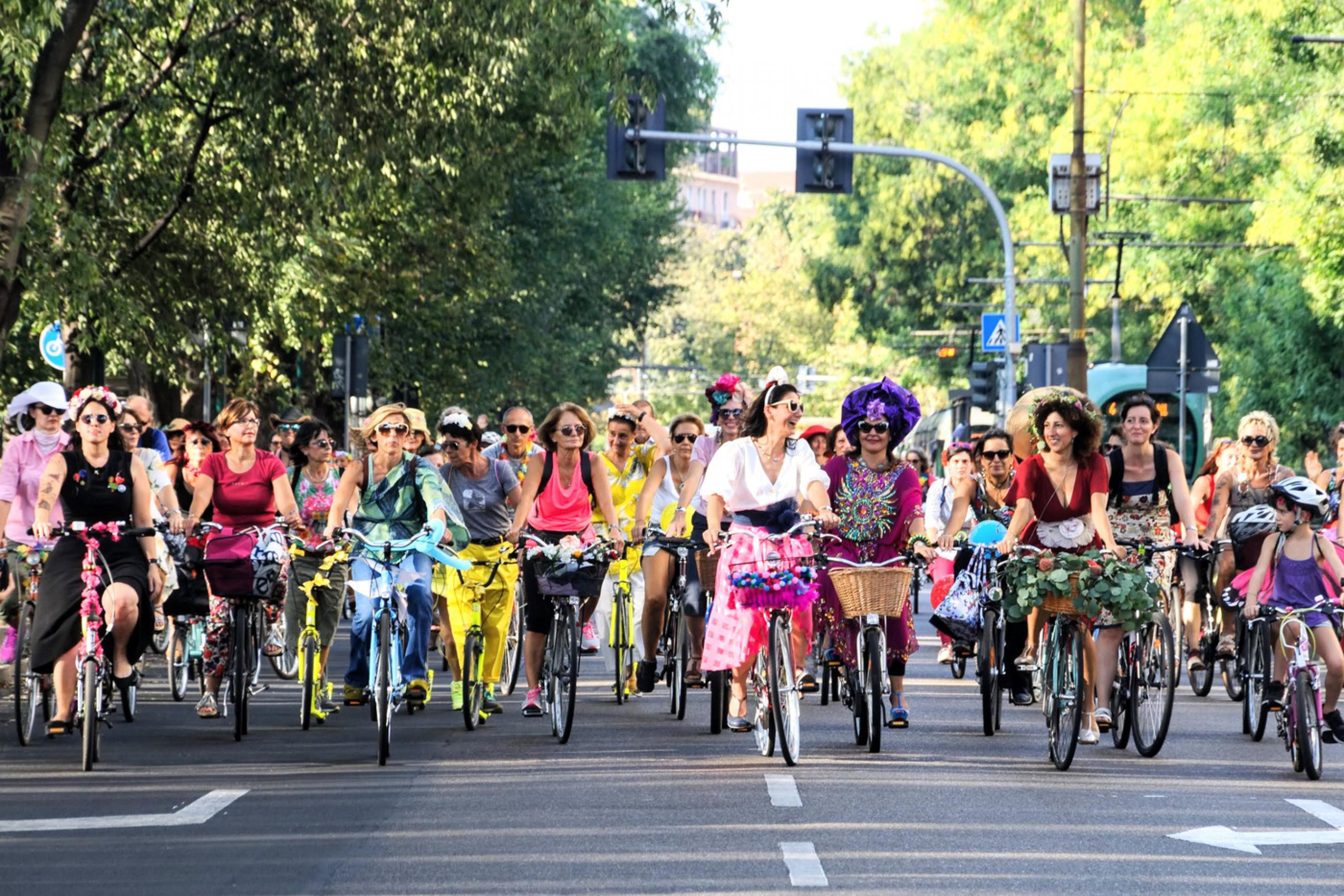 Beim autofreien Sonntag fahren in Milano Frauen und Kinder dicht gedrängt über zwei breite Fahrspuren. Sie tragen bunte Kleider und Hosen und haben ihre Räder mit Blumen und Girlanden geschmückt.