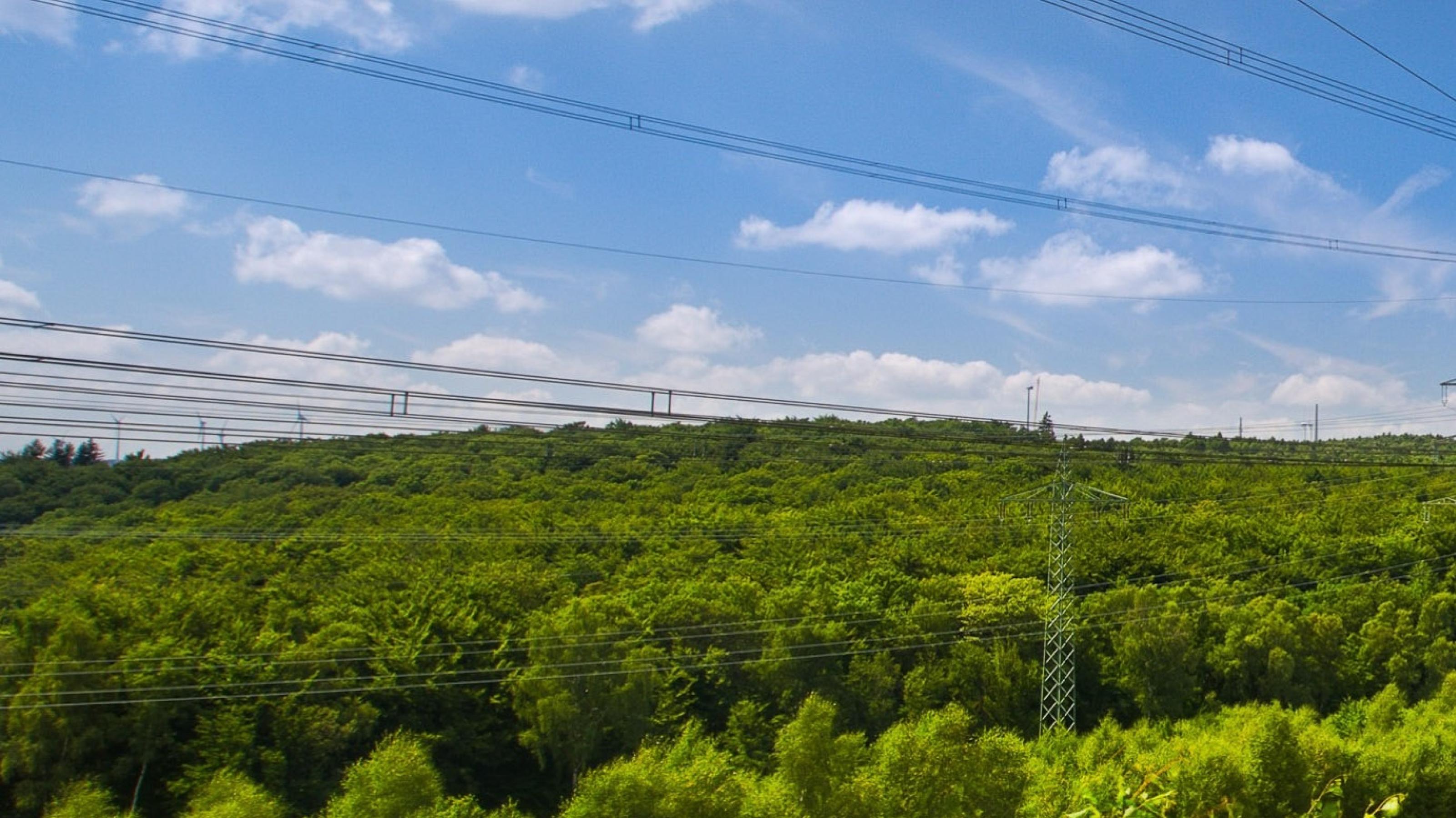 Das Bild zeigt eine Hochspannungsleitung auf freiem Feld.