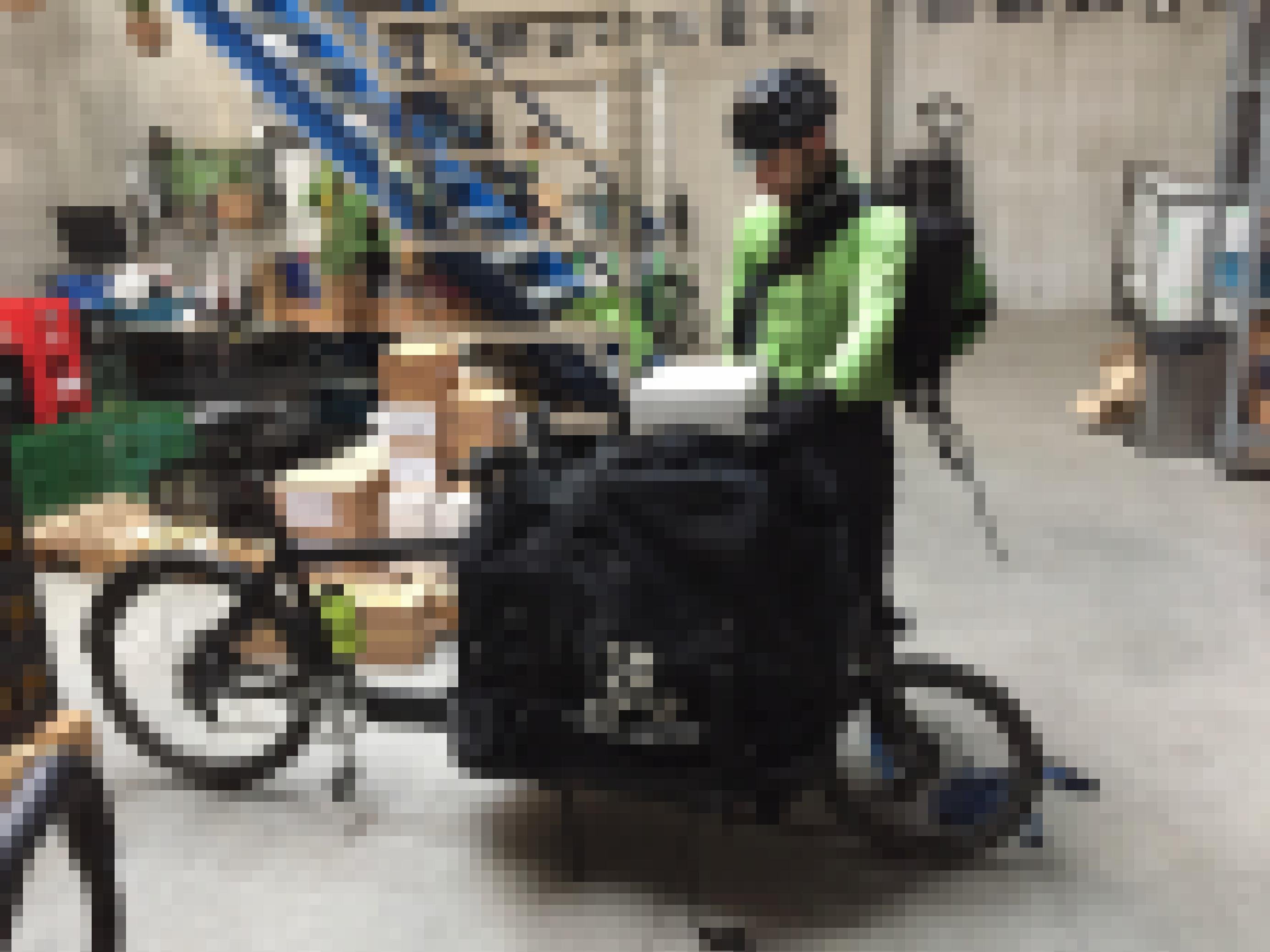Ein Kurierfahrer belädt die Tasche auf seinem Lastenrad in einem Lager.