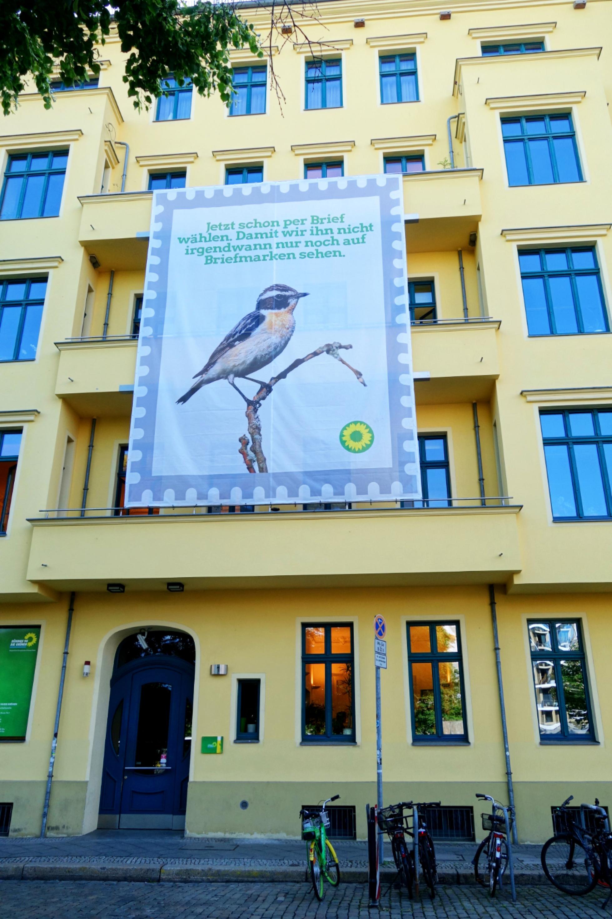 Ein Plakat mit einem Braunkehlchen fassadengroß an der Parteizentrale