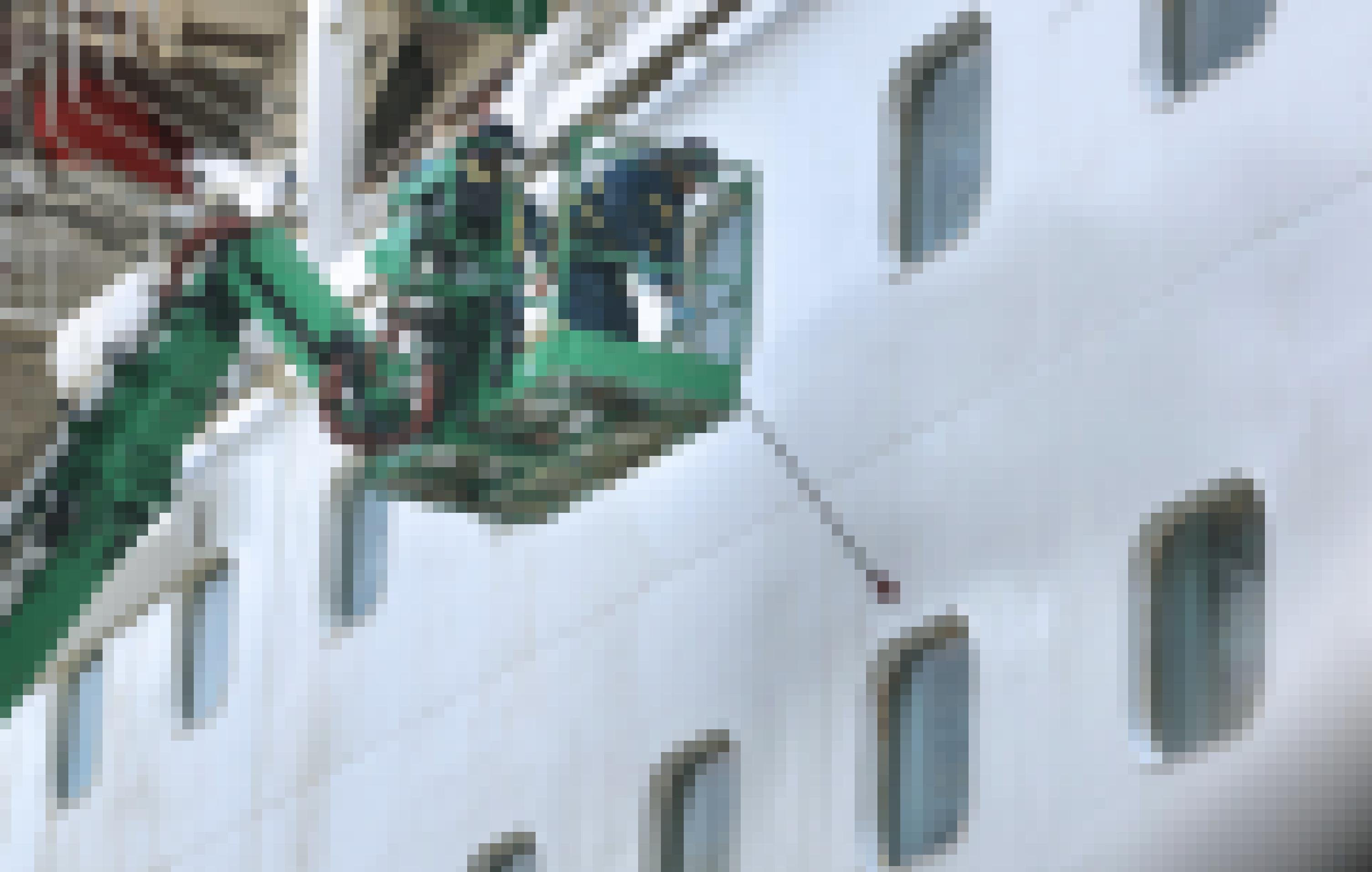Hafenmitarbeiter spritzen die Bullaugen eines Kreuzfahrtschiffes ab.