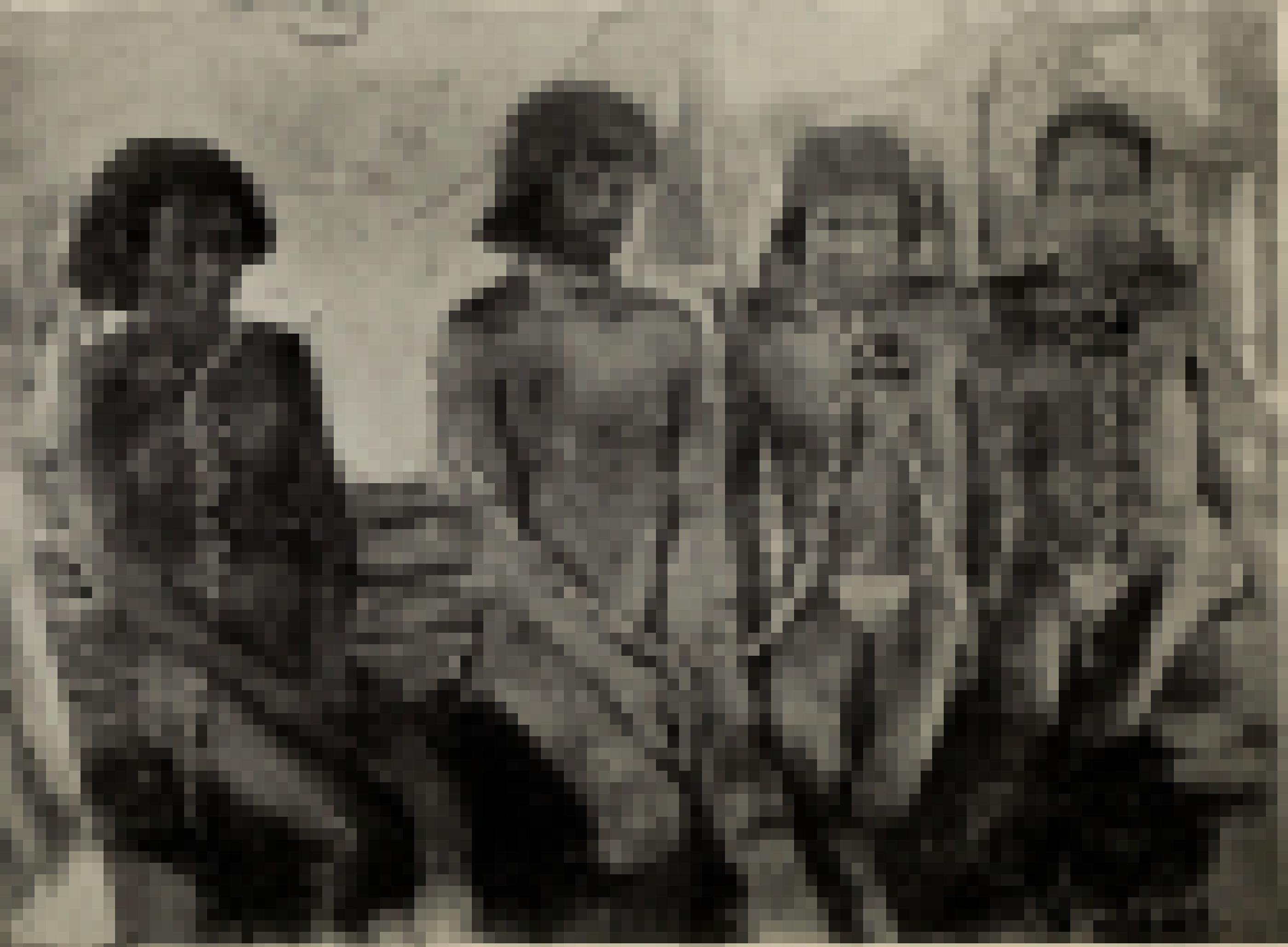 Das Schwarzweißfoto zeigt vier Indigene mit schweren Ketten um ihre Hälse.