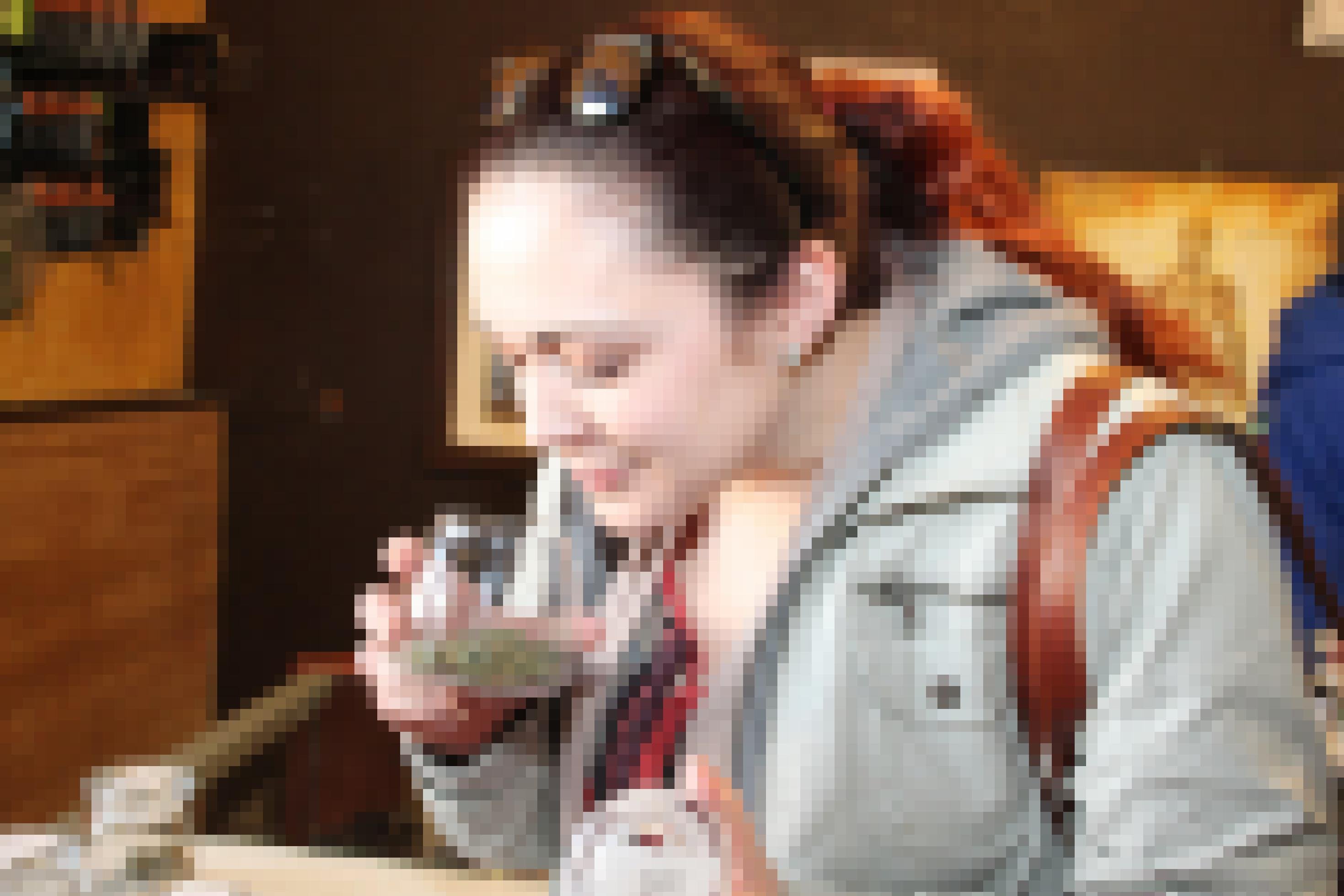 Eine junge Frau riecht an einer Dose mit Haschkeksen.