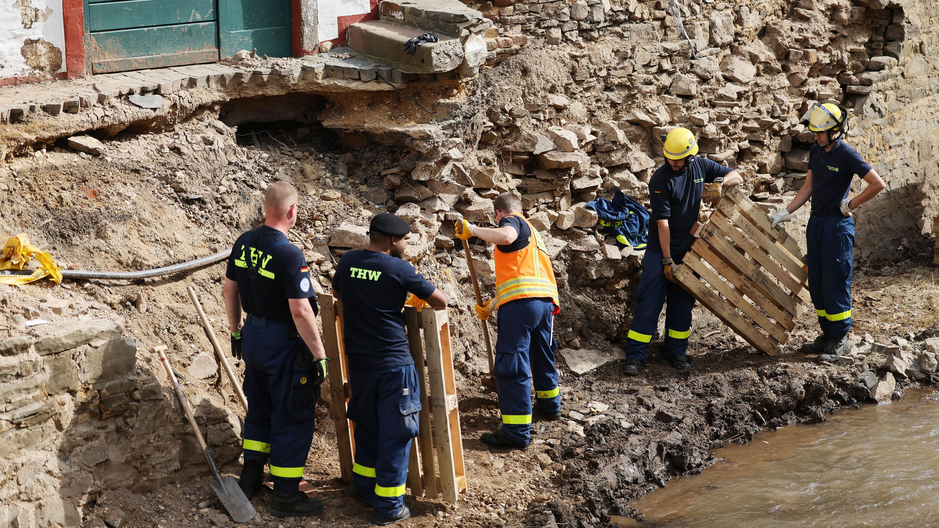 Helfer des THW arbeiten an der Absicherung eines Gebäudes an der Erft. Das Hochwasser hat erhebliche Schäden in der Eifel angerichtet.