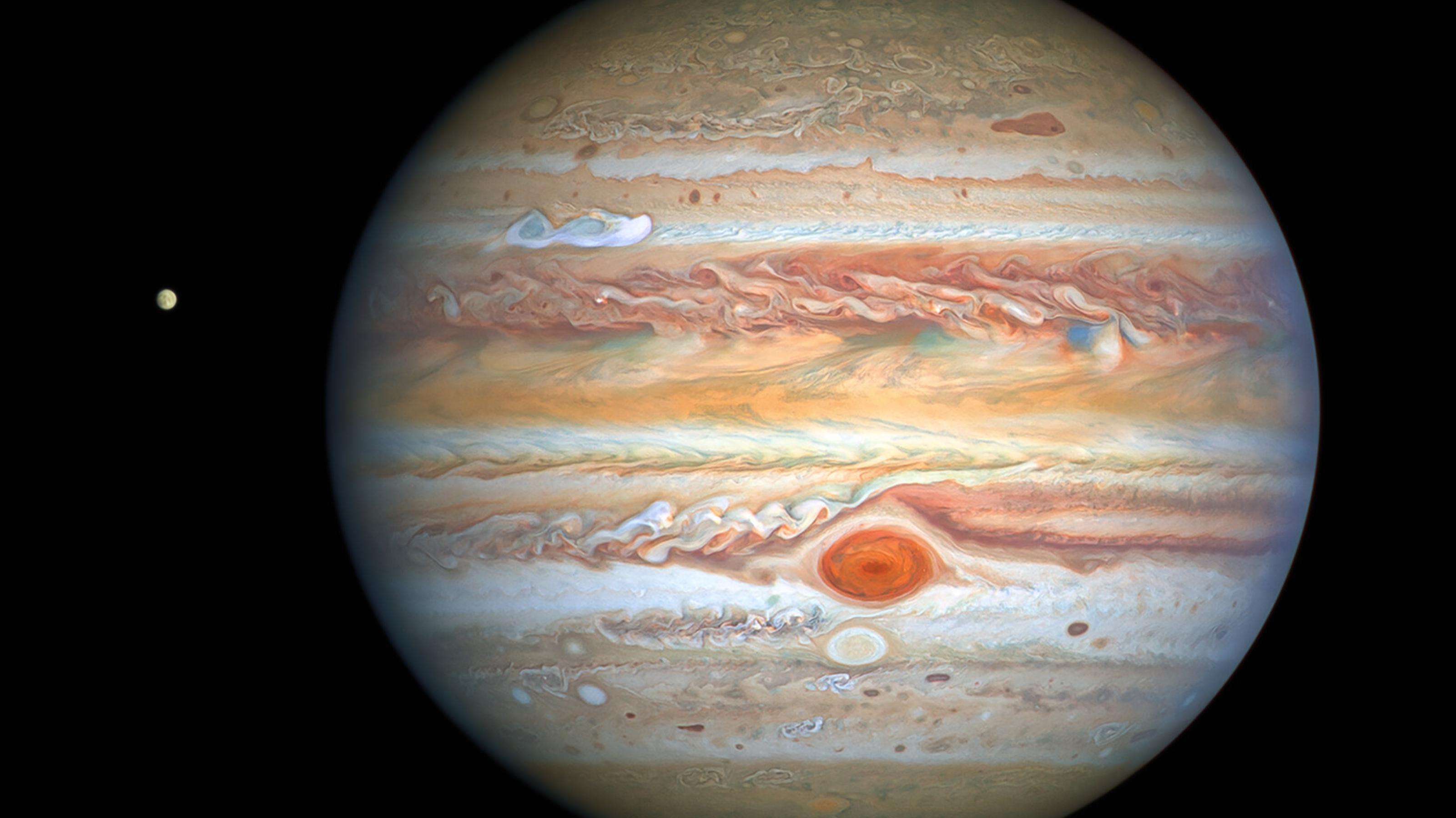 Das Bild zeigt den Gasriesen Jupiter. Links neben ihn ist auch einer seiner Eismonde zu erkennen: Europa. Der Hintergrund ist schwarz und sternenlos.