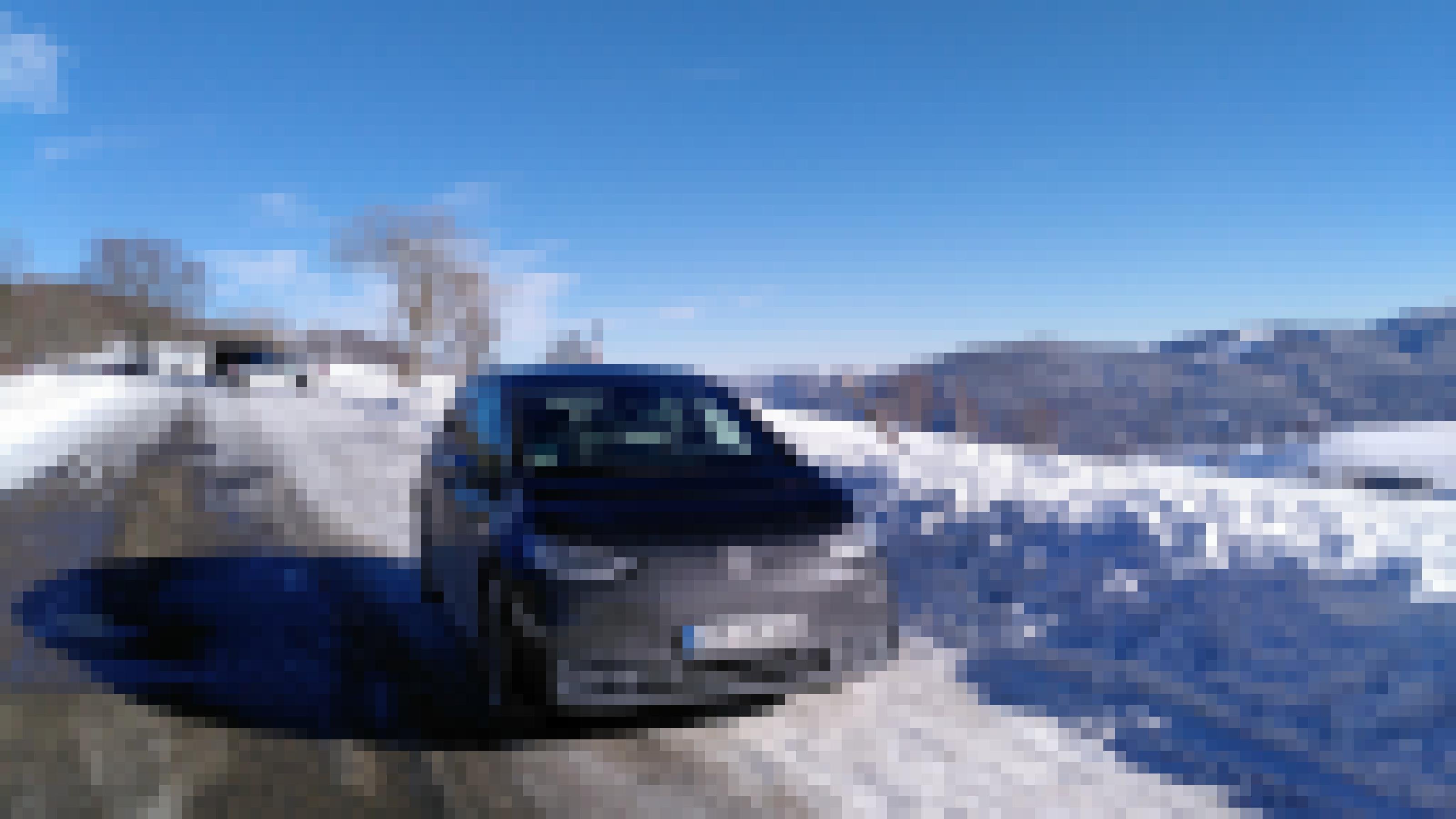 Ein schwarzes Auto parkt inmitten einer Schnee-Landschaft.
