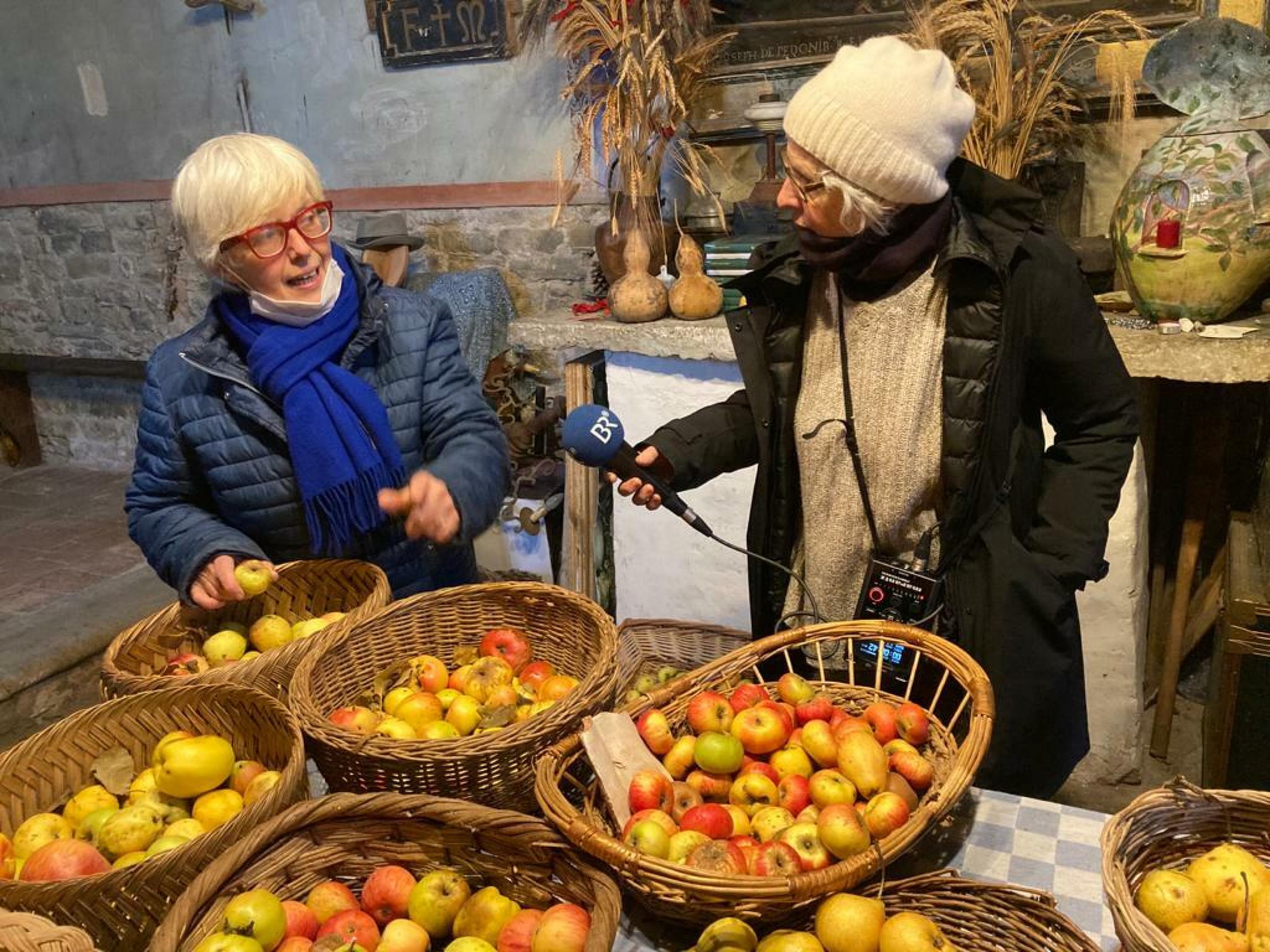 Isabella Dalla Ragione vor Körben mit unterschiedlichen Äpfeln.
