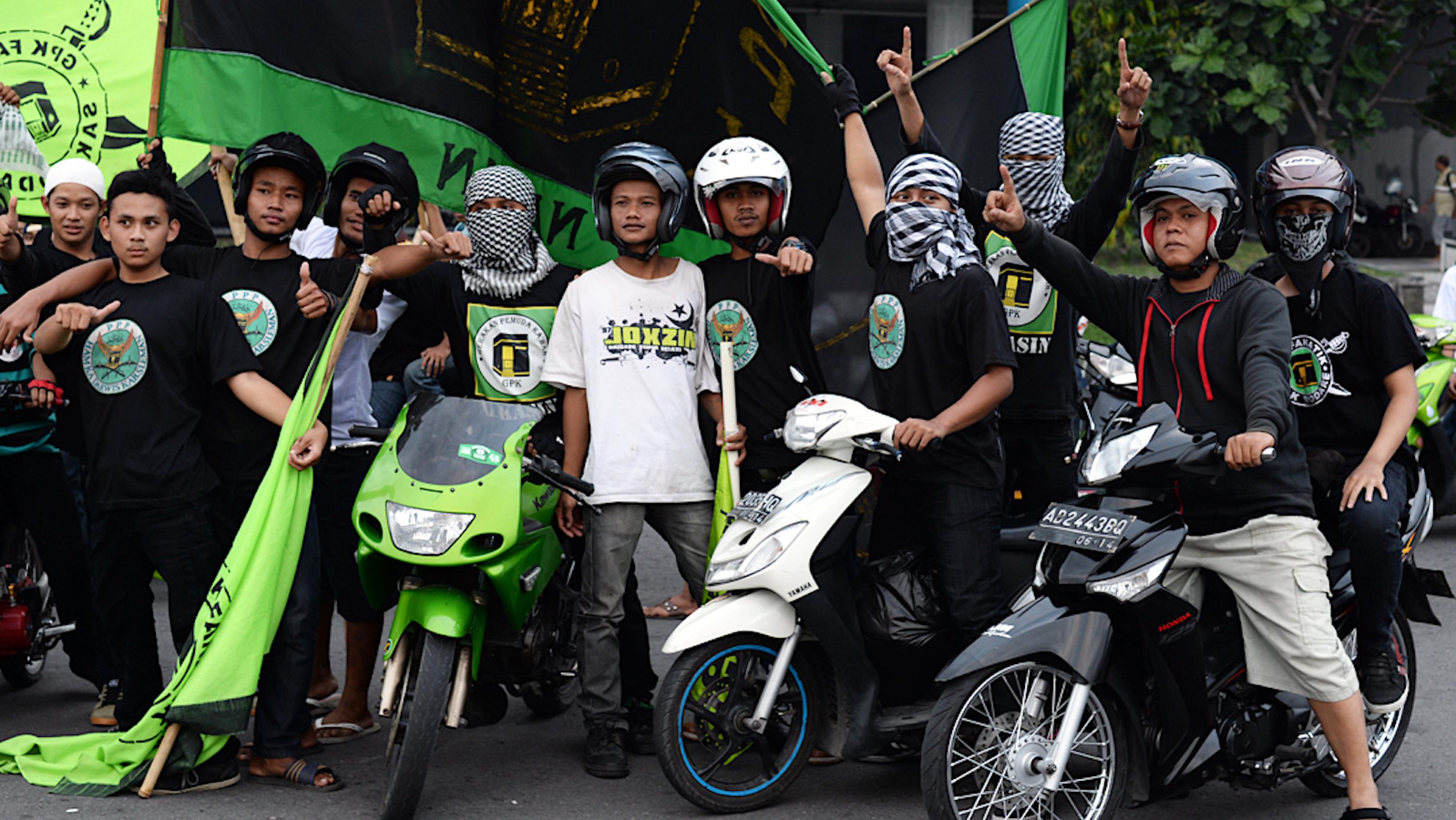 Junge Indonesier demonstrieren auf Mopeds mit Fahnen der Ka’abah-Jugendbewegung (GPK)