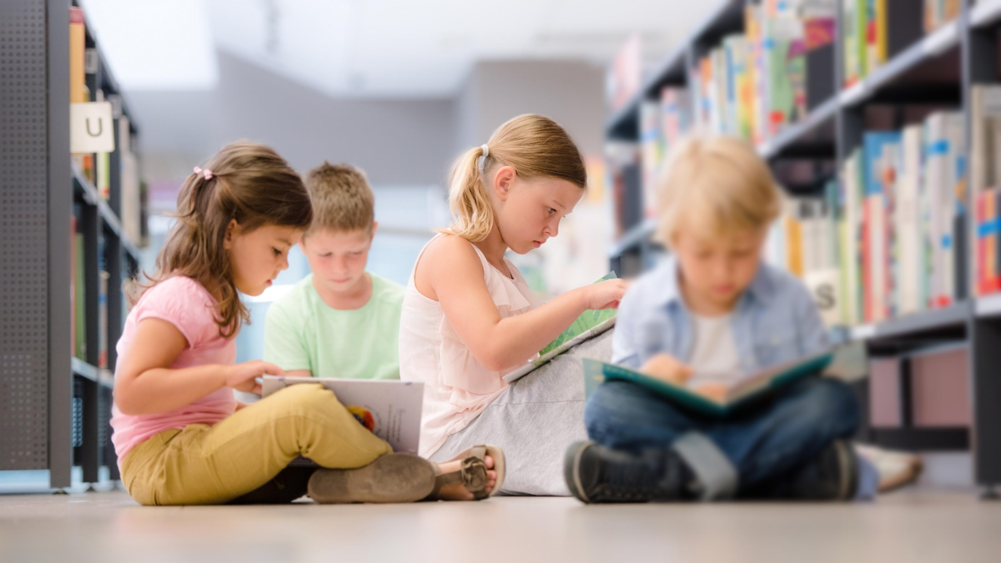 Symbolfoto zur Pisa-Studie: kleine Kinder lesen in einer Bibliothek