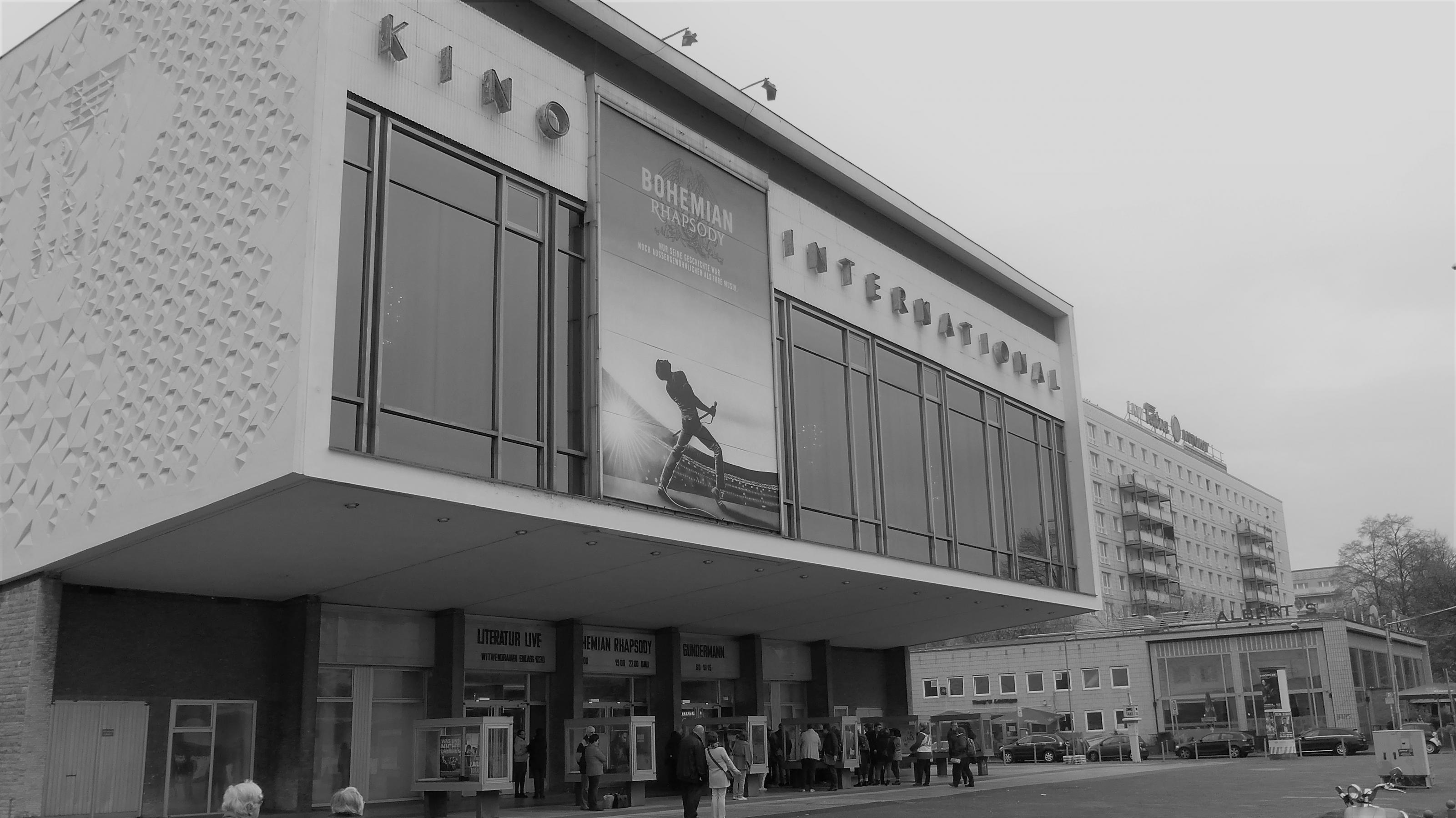 Fassade des Kino International in der Berliner Karl-Marx-Allee. Über den  drei Eingängen angekündigt: „Bohemian Rhapsody“, „Gundermann“ und „Literatur Live“. An der Frontseite über den Eingängen hängt ein Plakat von „Bohemian Rhapsody“ in etwa sechsfacher Passantengröße.