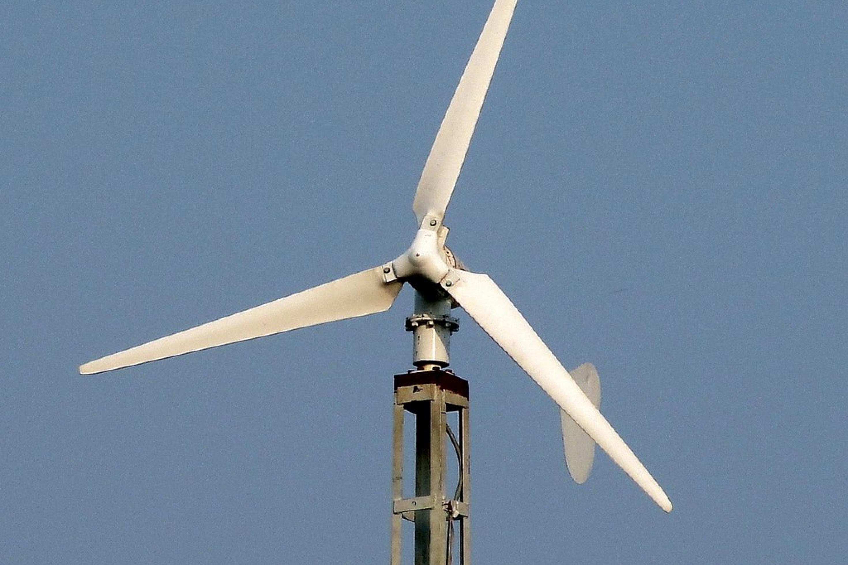Rotor einer kleinen Windkraftanlage vor blauem Himmel