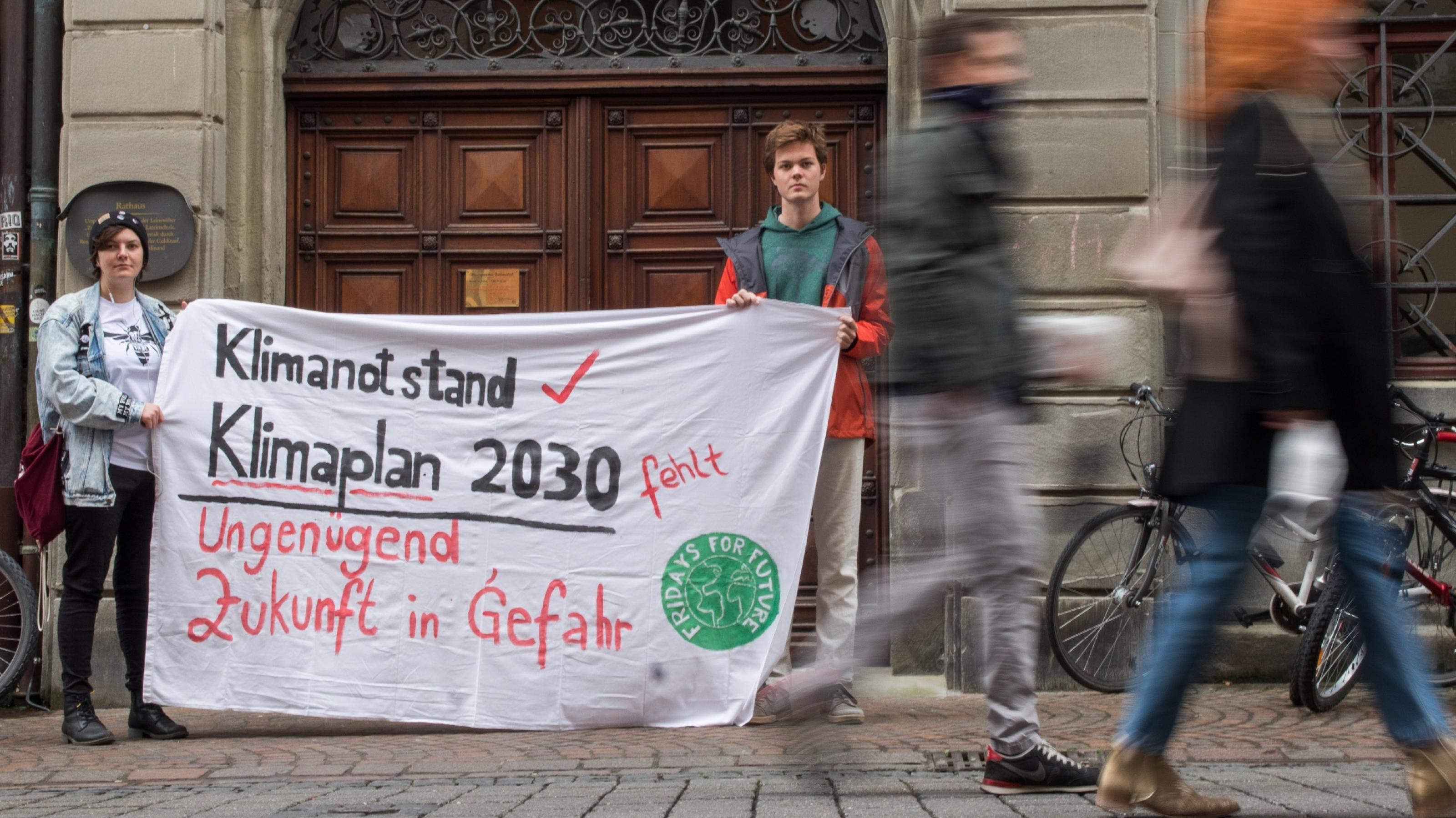 Zwei Aktivisten von Fridays for Future protestieren vor dem Rathaus in Konstanz.
