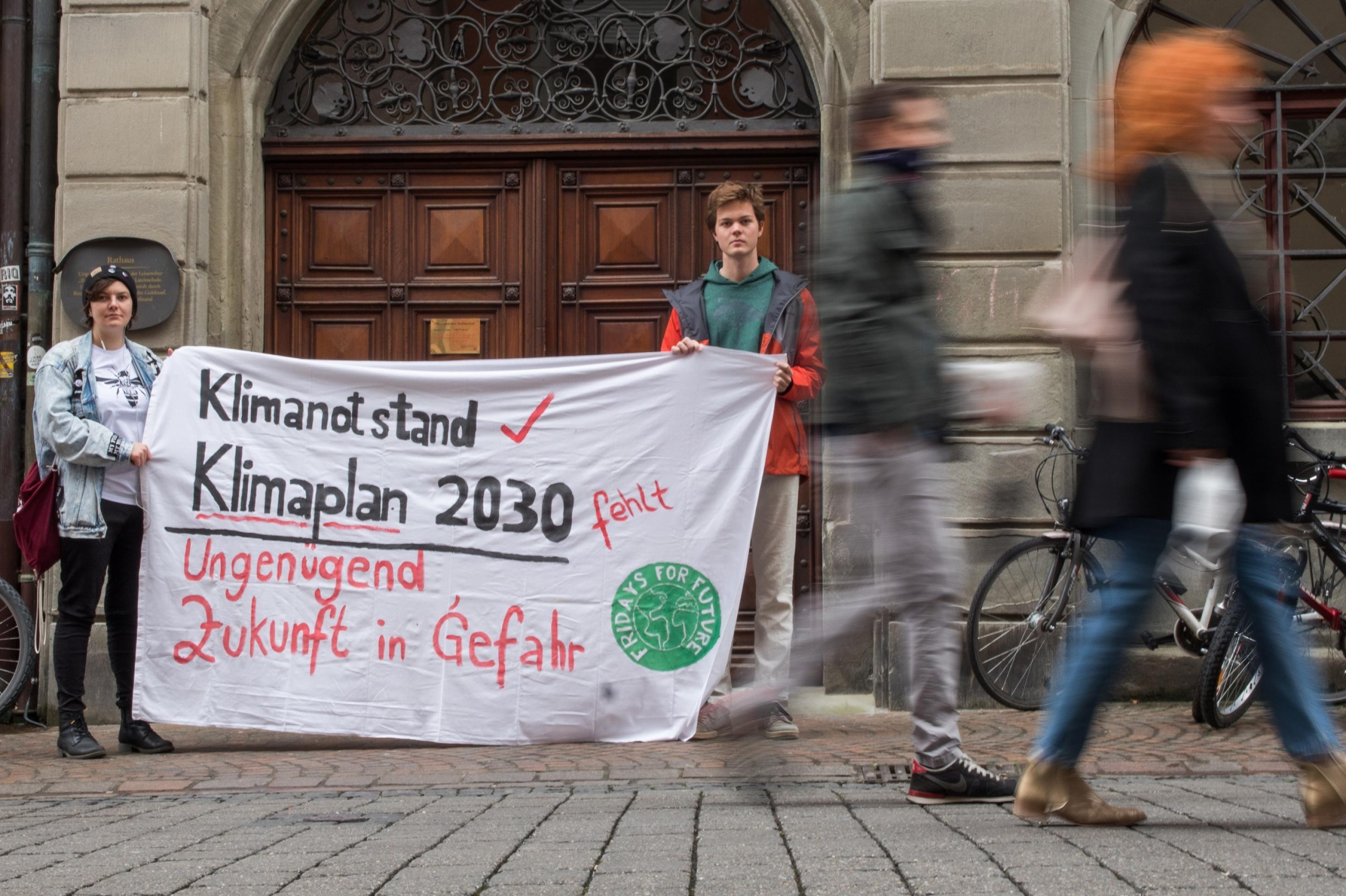 Zwei Aktivisten von Fridays for Future protestieren vor dem Rathaus in Konstanz.