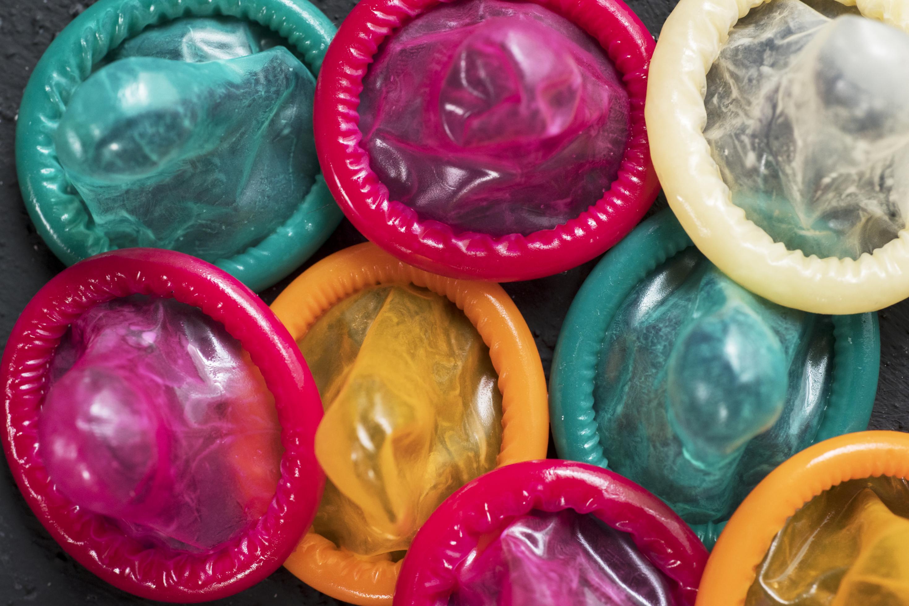 Ein Haufen Kondome in Pink, Grün, Gelb und Natur