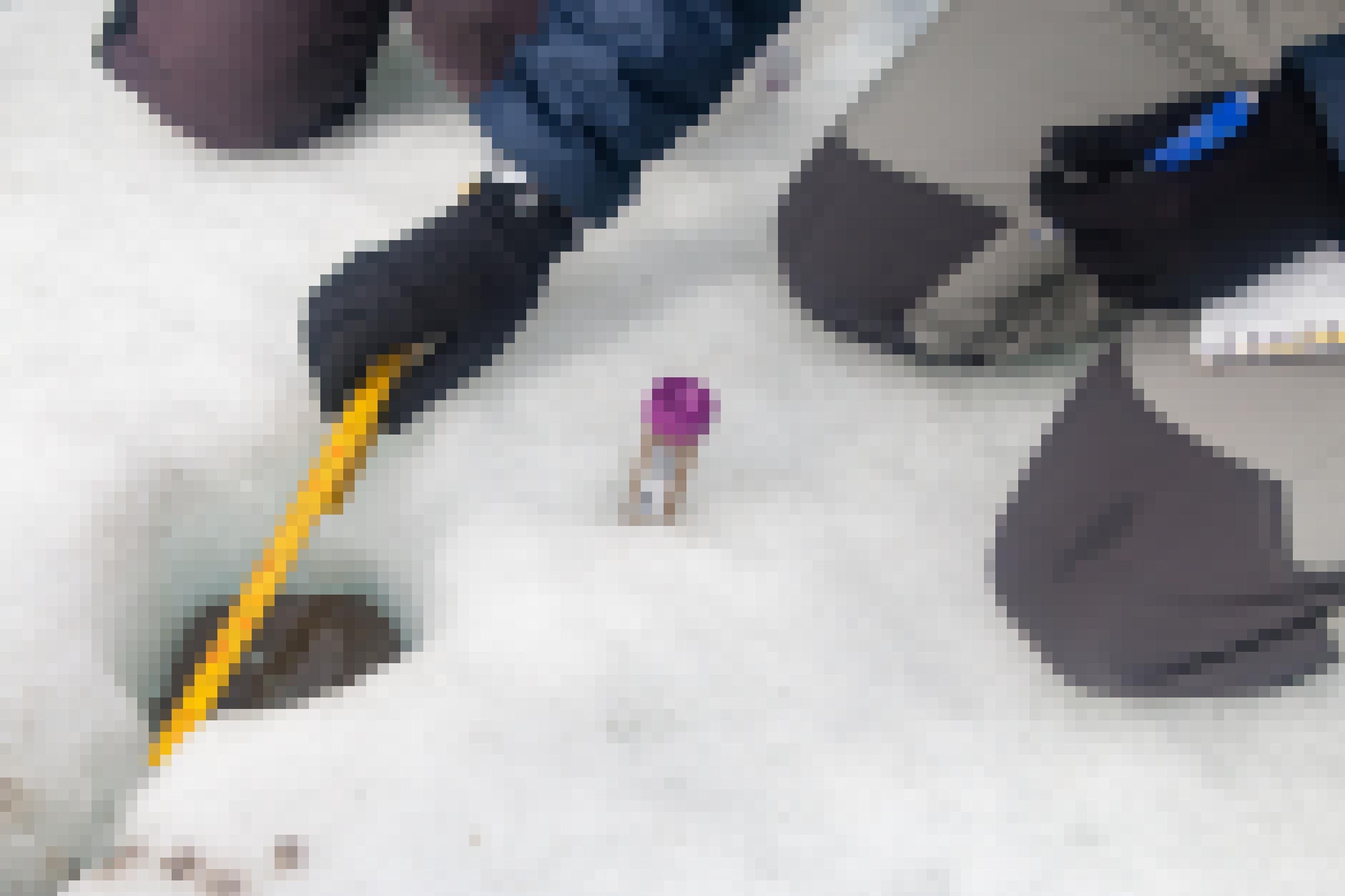 Eine behandschuhte Hand hält einen Zollstock über eine Eisvertiefung.