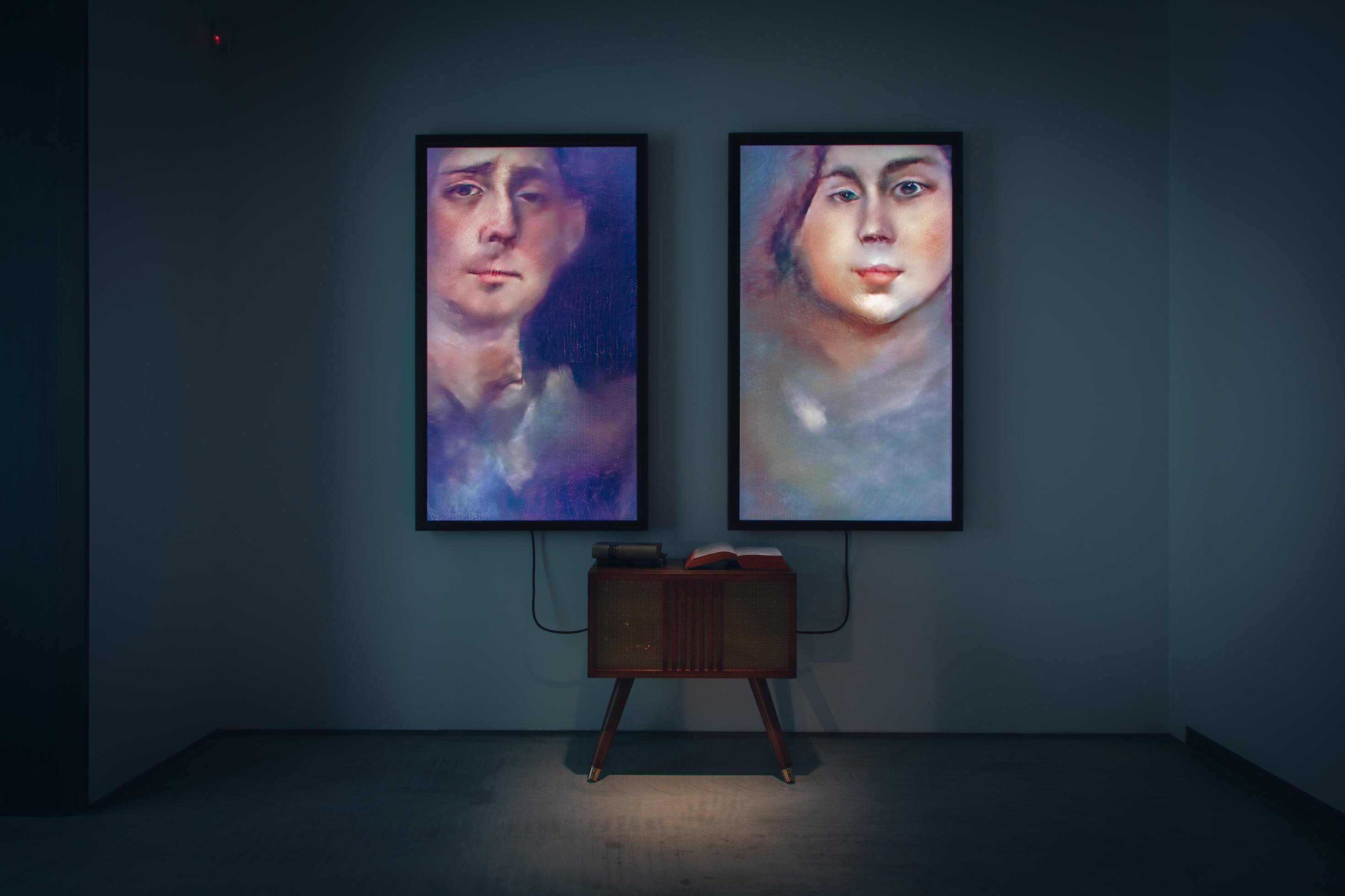 Eine künstliche Intelligenz erzeugt kontinuierlich Porträts von Menschen auf zwei Bildschirmen. Installation des deutschen Digitalkünstlers Mario Klingemann mit dem Titel „Memories of Passersby I“.
