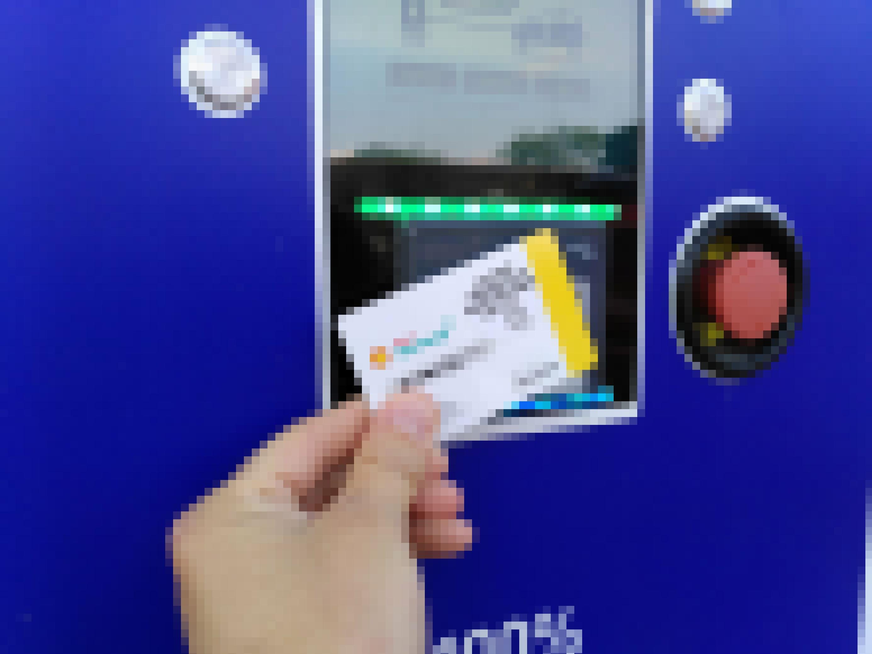 Eine Hand hält eine Plastikkarte vor ein Kartenlesegerät.