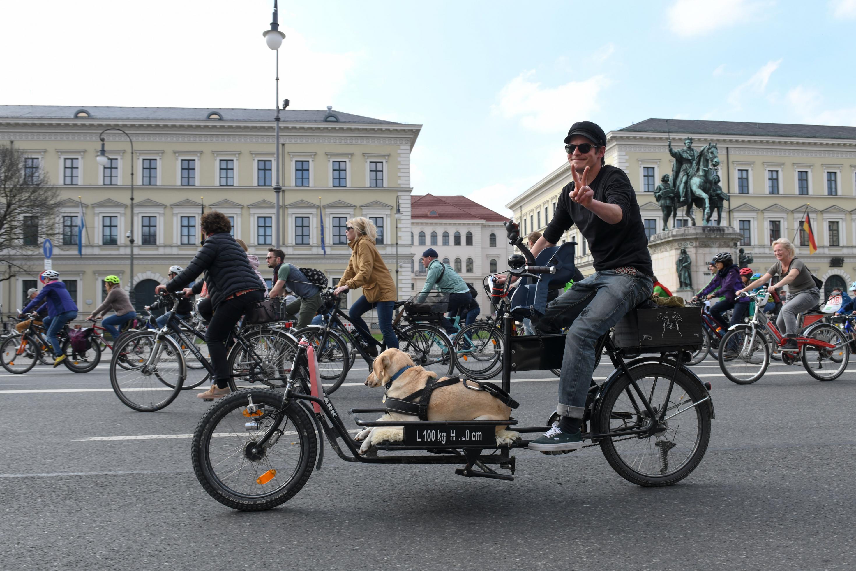 Das Bild zeigt einen Teilnehmer der Radsternfahrt im April 2019 in München. Auf seinem Lastenrad liegt ein Hund.