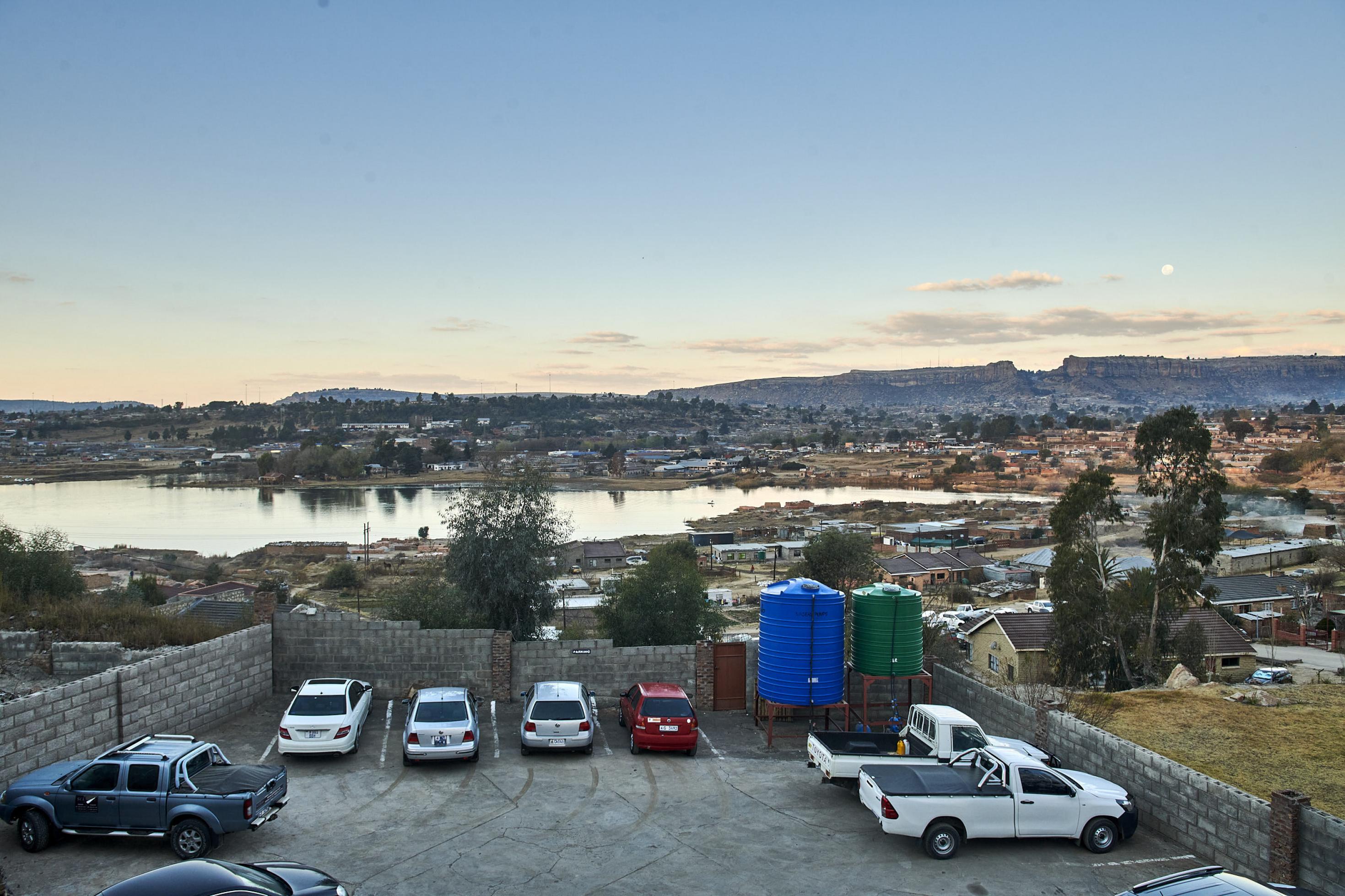 In der Hauptstadt Maseru liegt ein See hinter einem Parkplatz