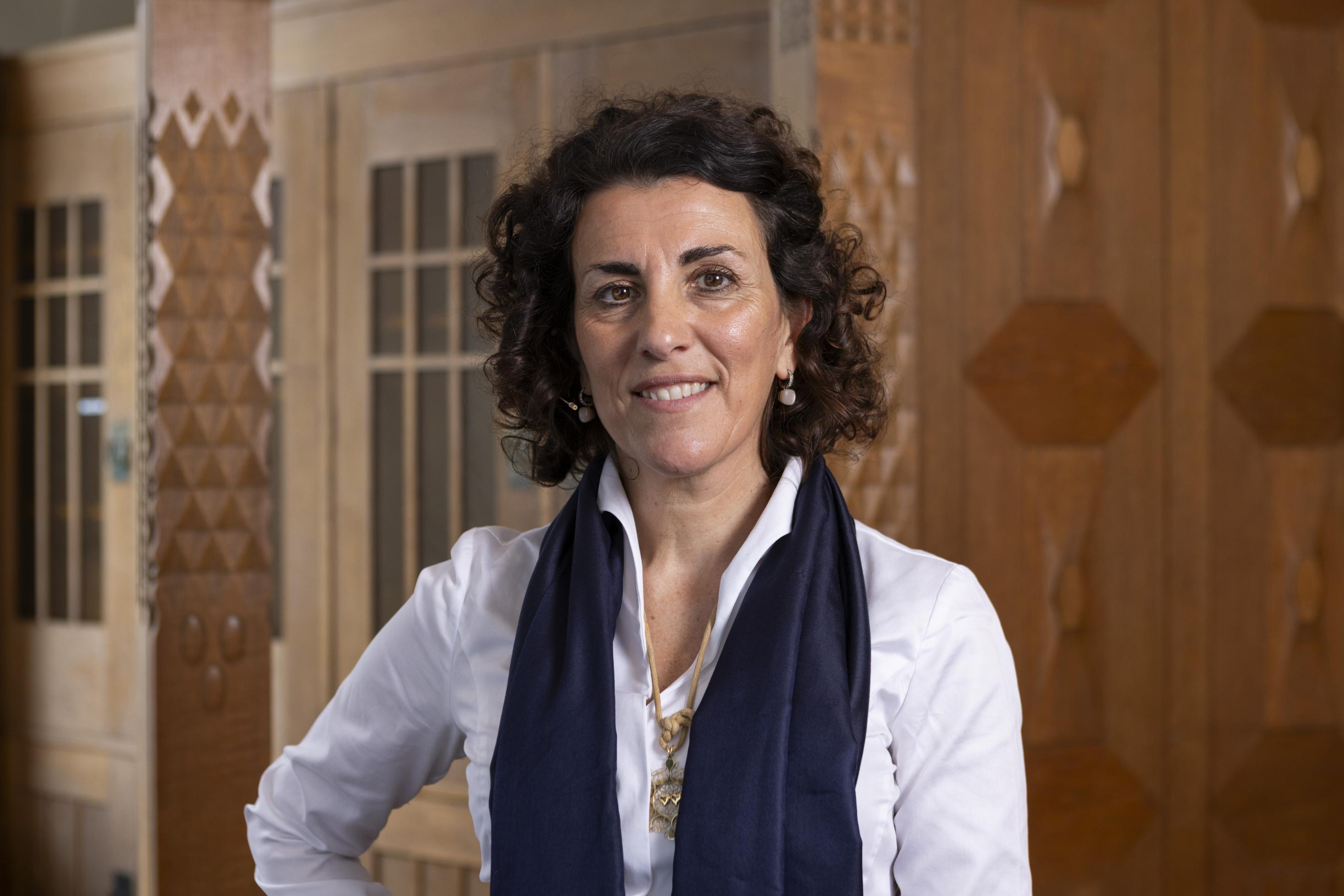 Eine Frau mittleren Alters mit dunkeln lockigen Haaren