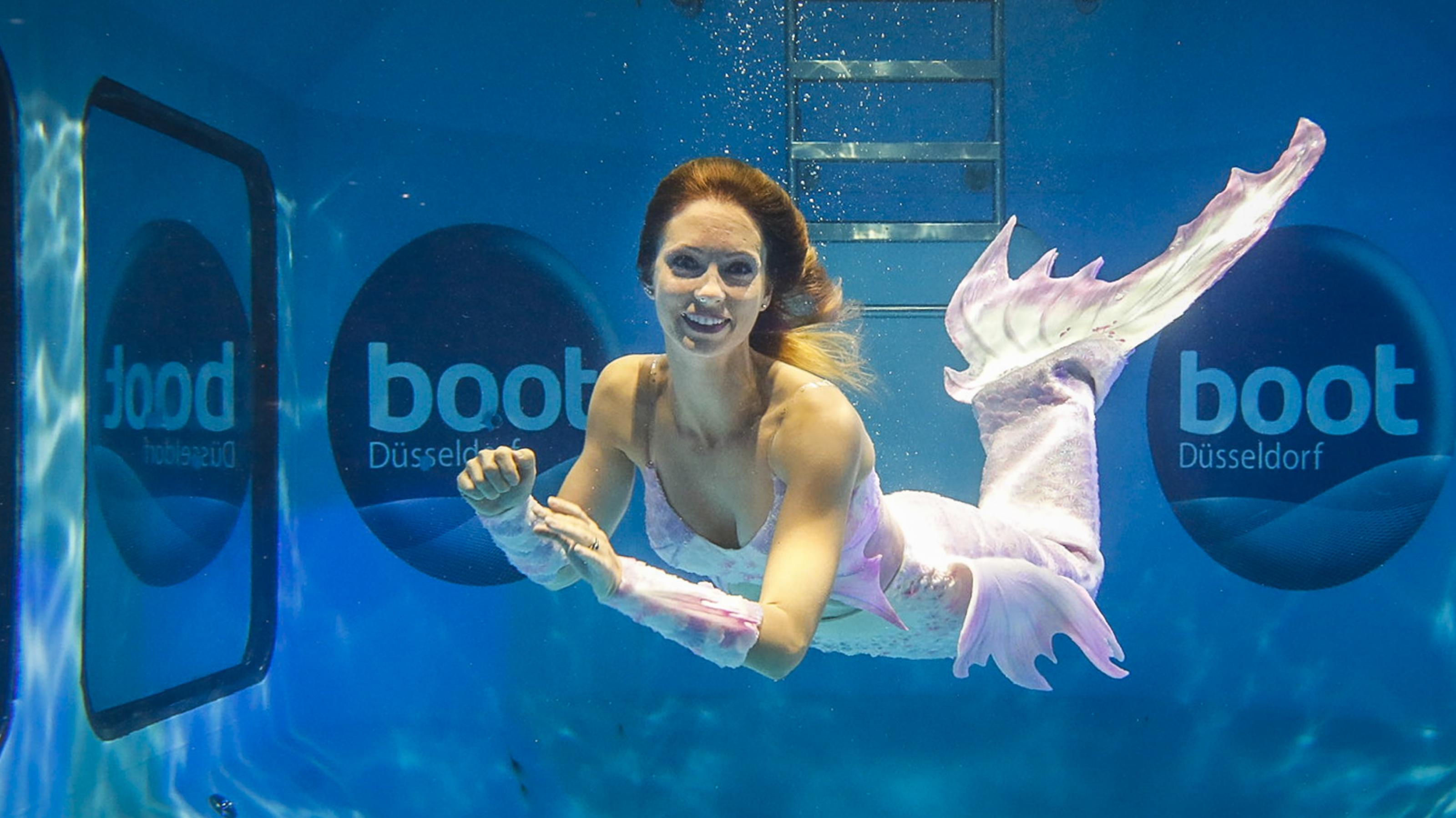 Meerjungfrau schwimmt in einem Tauchbecken